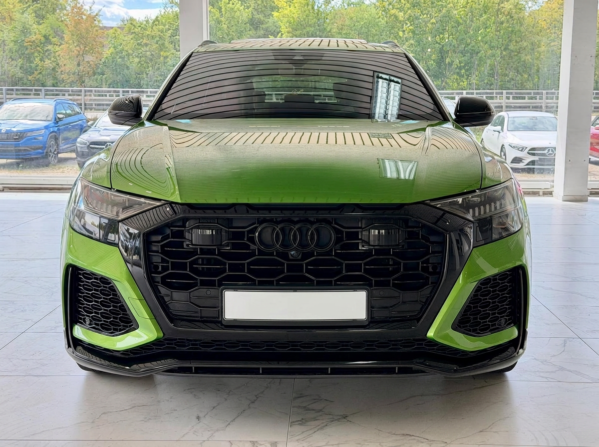 Head-on front view of the green Audi RS Q8 showing the RS honeycomb grille and black optics package.