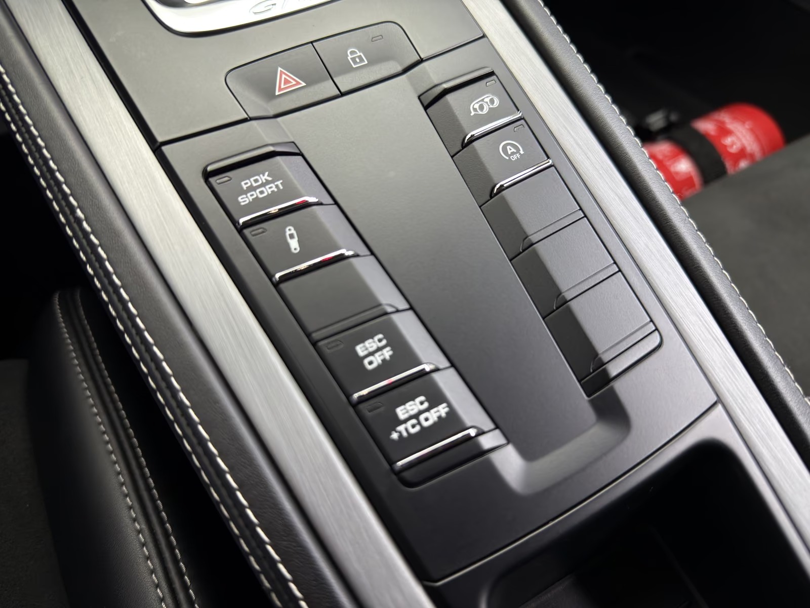 Console switch panel of the Porsche 718 Cayman GT4 showing the PDK Sport, ESC OFF and ESC+TC OFF buttons.