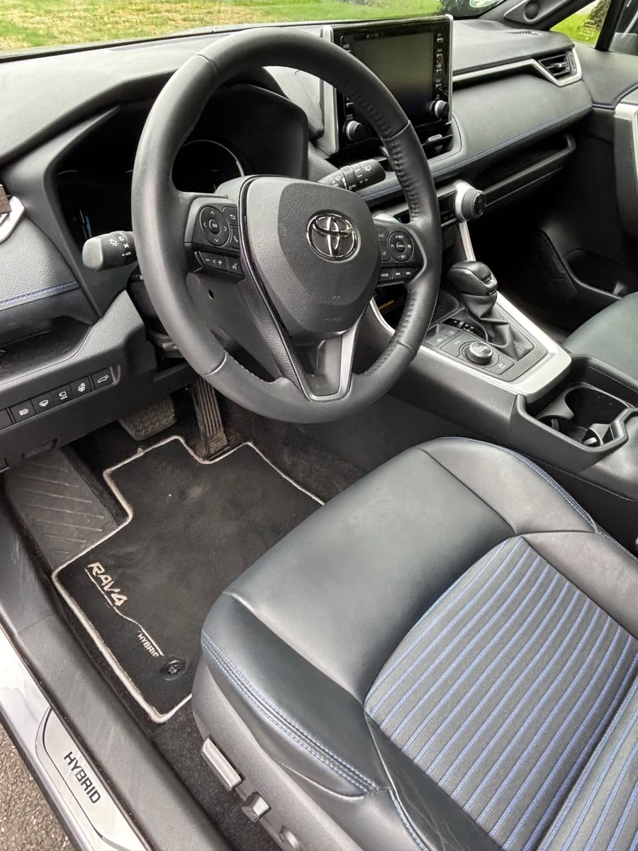 Cockpit of the Toyota RAV4 Hybrid with leather steering wheel and infotainment screen.