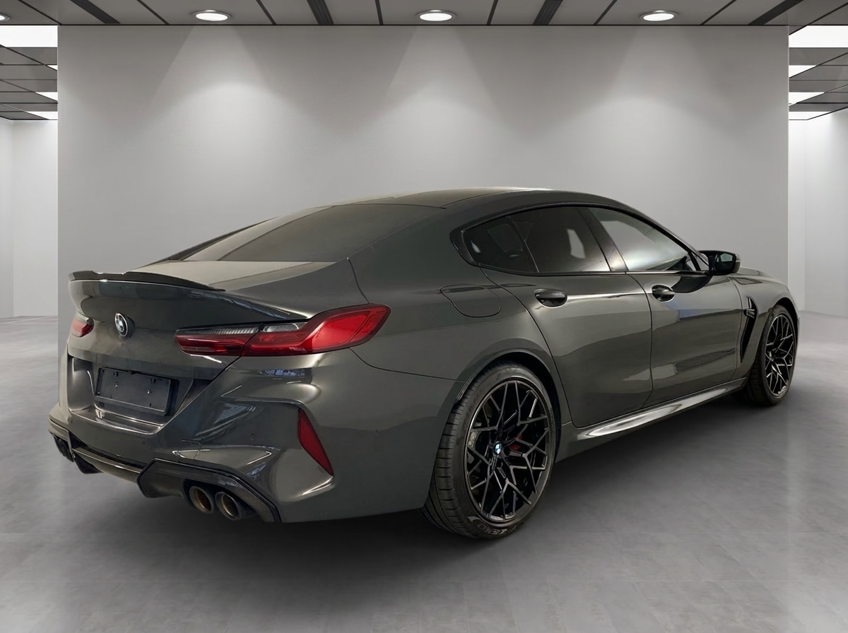 BMW M8 Competition Gran Coupé 2023 — rear three-quarter view with carbon spoiler