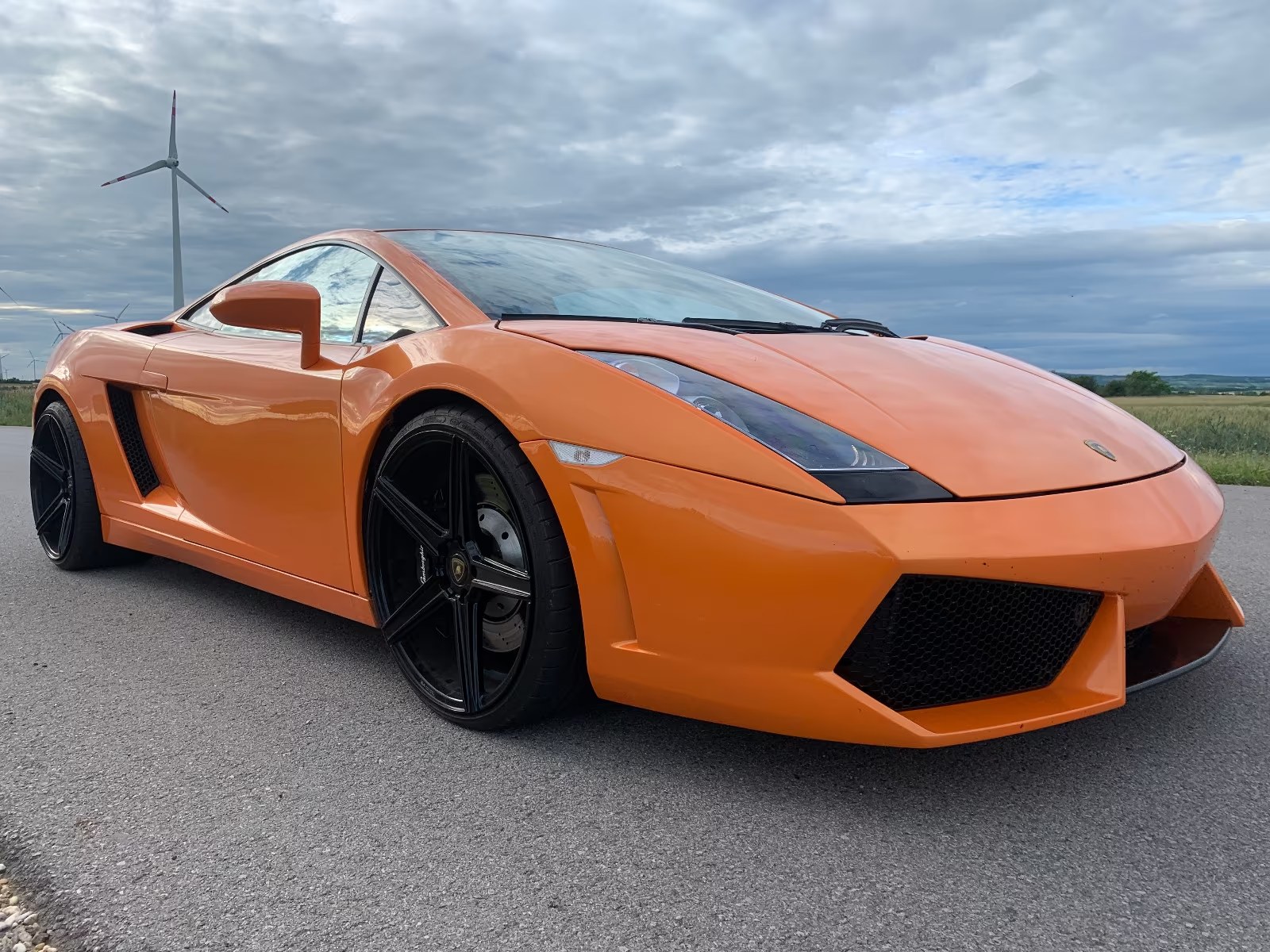Orange Lamborghini Gallardo front three-quarter view on a country road