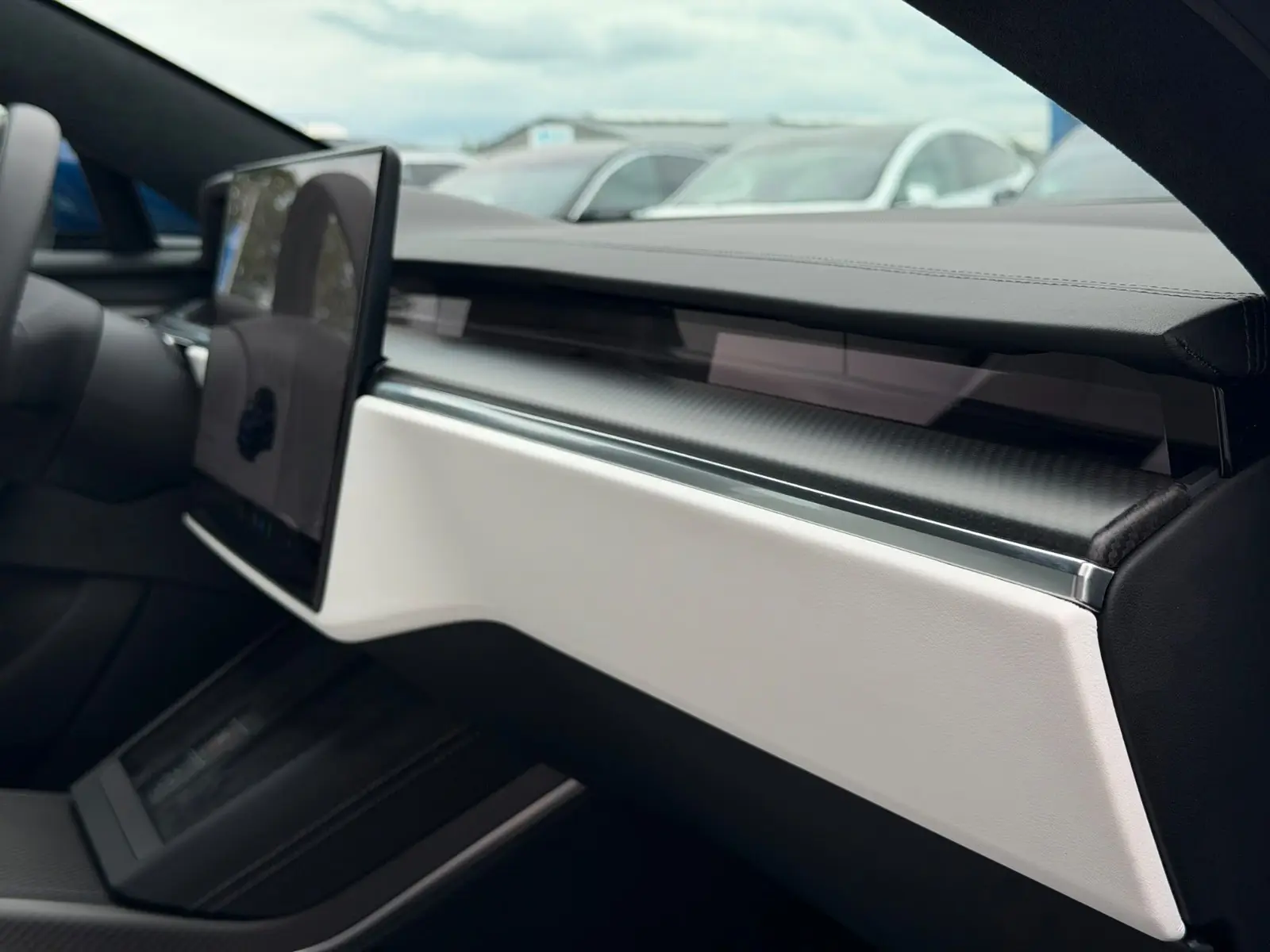Tesla Model S Plaid dashboard with central touchscreen and carbon fibre trim.