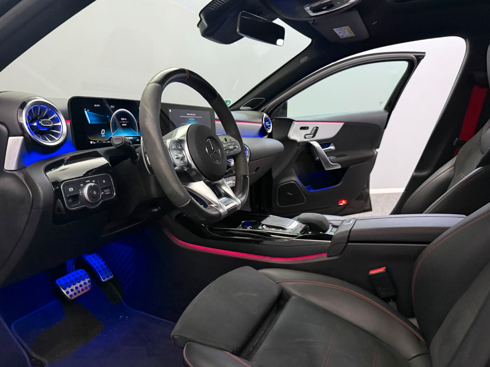 Mercedes-AMG A 35 4MATIC 2021 — driver's cockpit with AMG steering wheel and ambient lighting