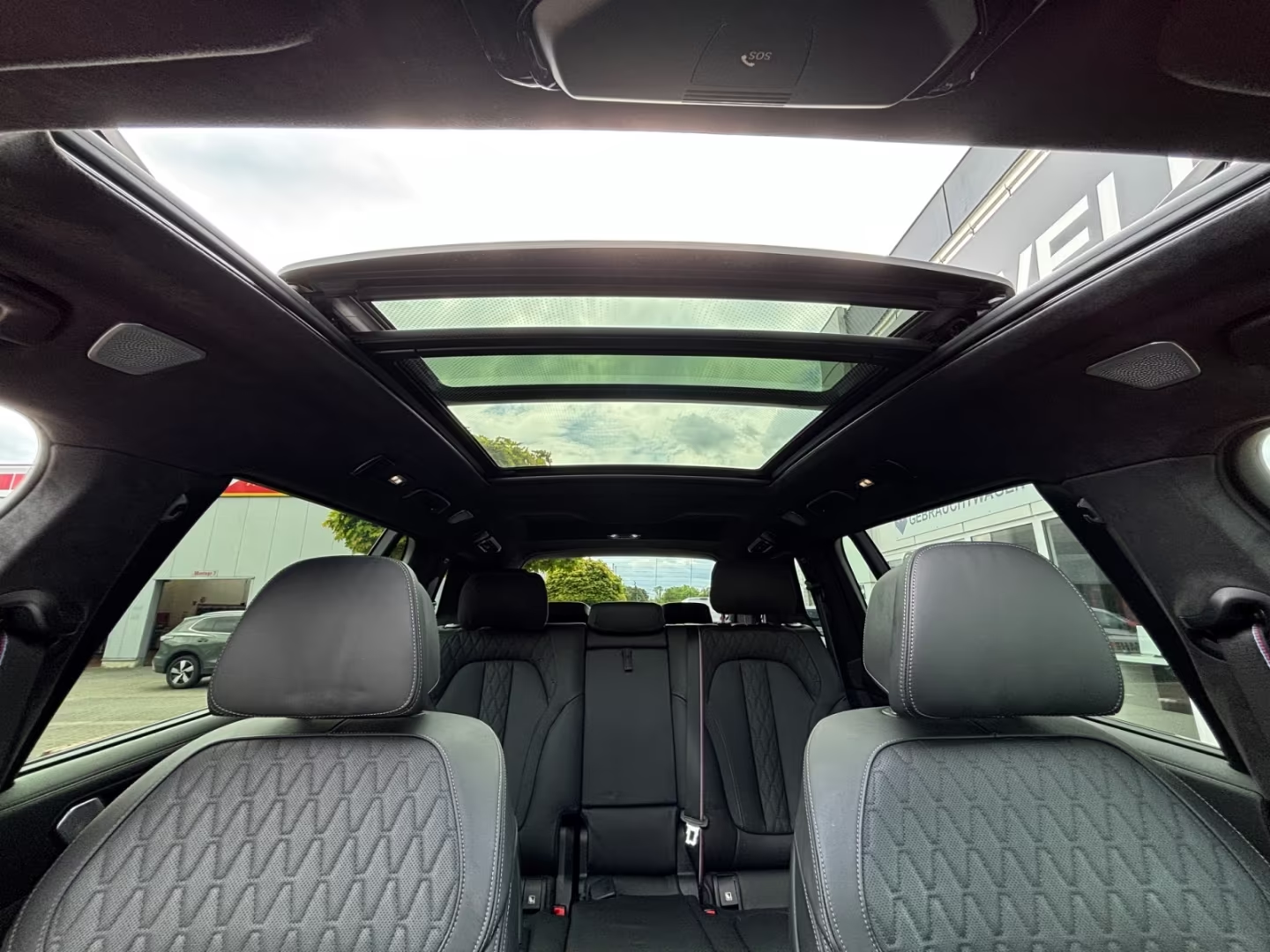 Panoramic glass roof and quilted black leather interior of the BMW X7.