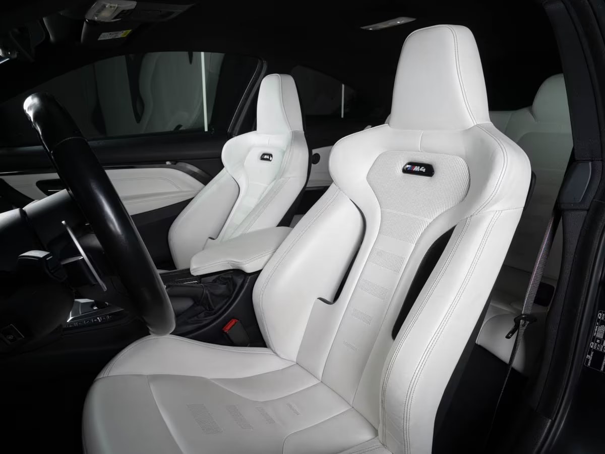 Opal White leather M sport seats with illuminated M4 badging on the backrests.