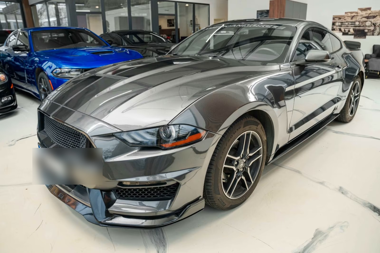 Ford Mustang Fastback in grey metallic, front three-quarter view in showroom
