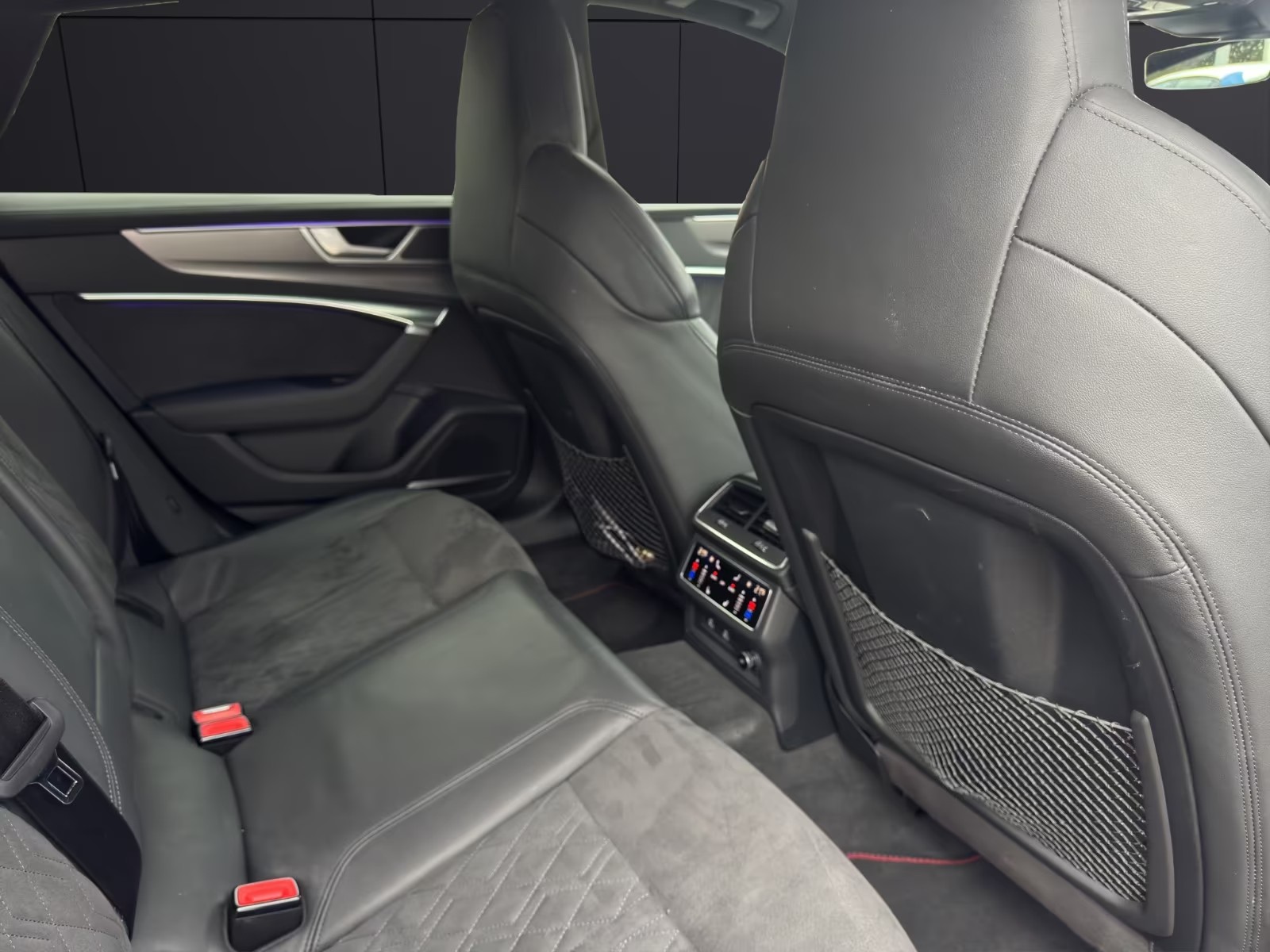 Rear seats of the Audi RS7 in black Alcantara with diamond stitching and rear climate controls.