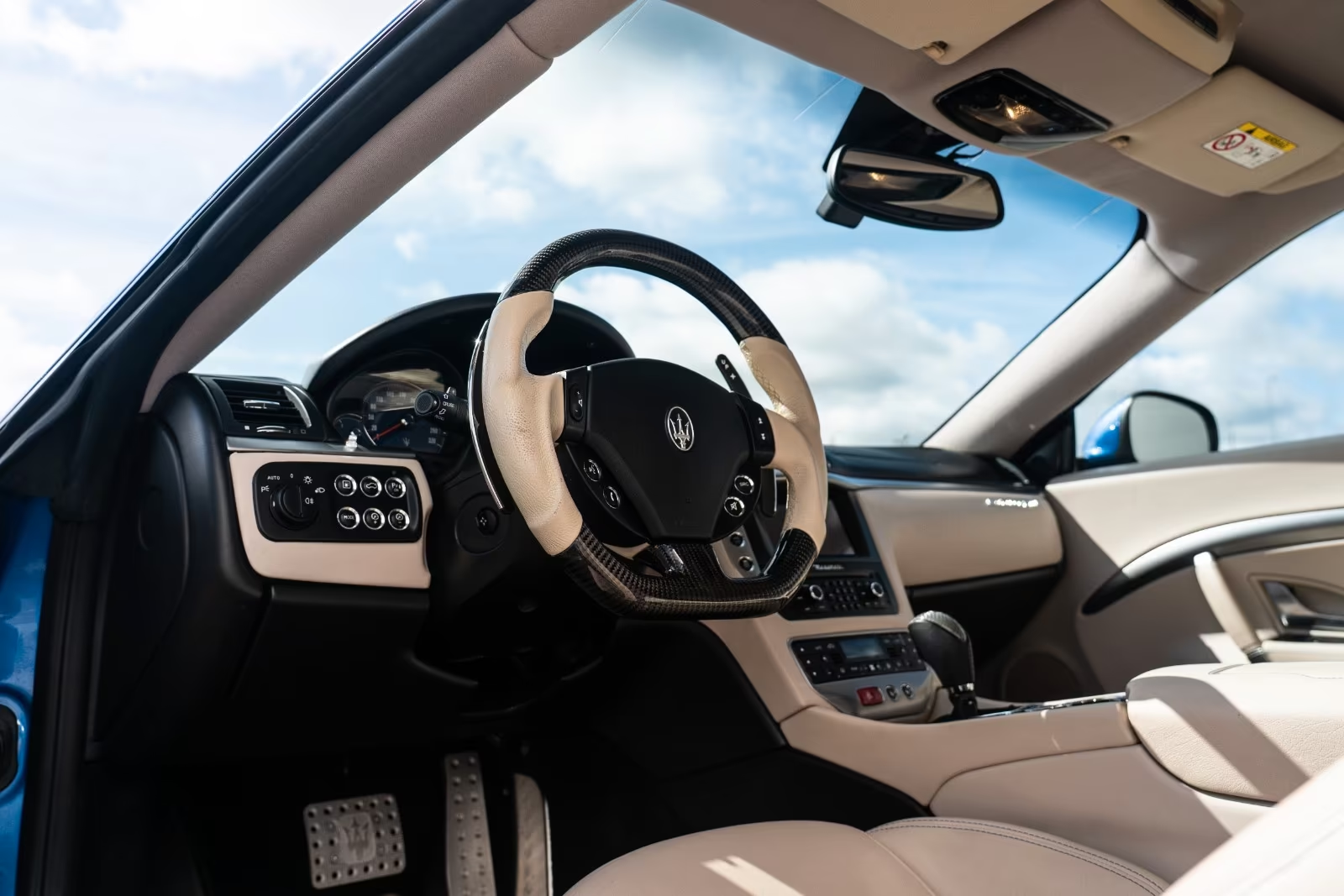Carbon fibre and leather steering wheel and cockpit of the Maserati GranTurismo Sport.