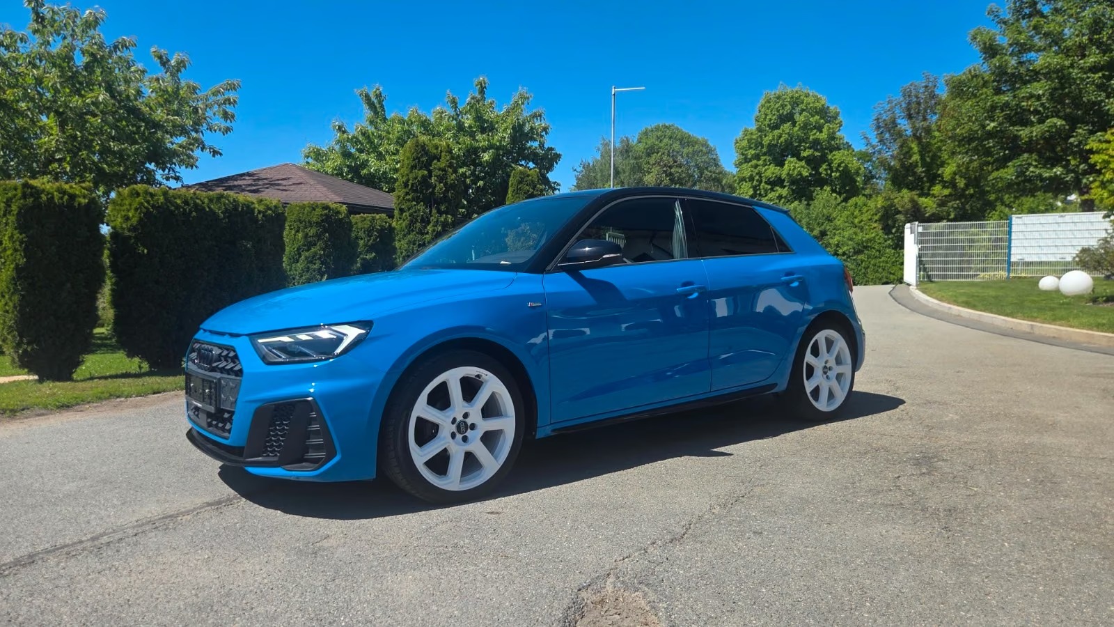 Side profile of the blue Audi A1 Sportback showing the five-door bodystyle and white alloy wheels.