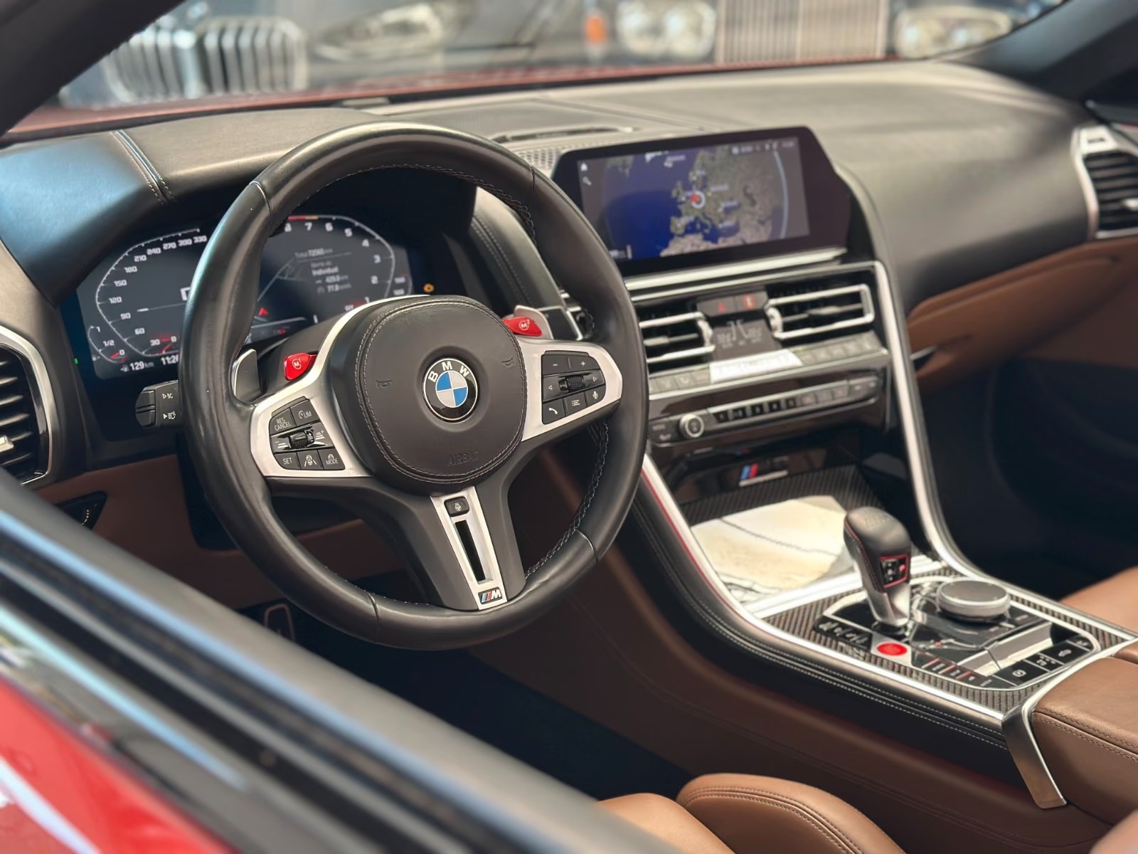 Driver's view of the BMW M8 cockpit with the M steering wheel, digital instrument display and central navigation screen.