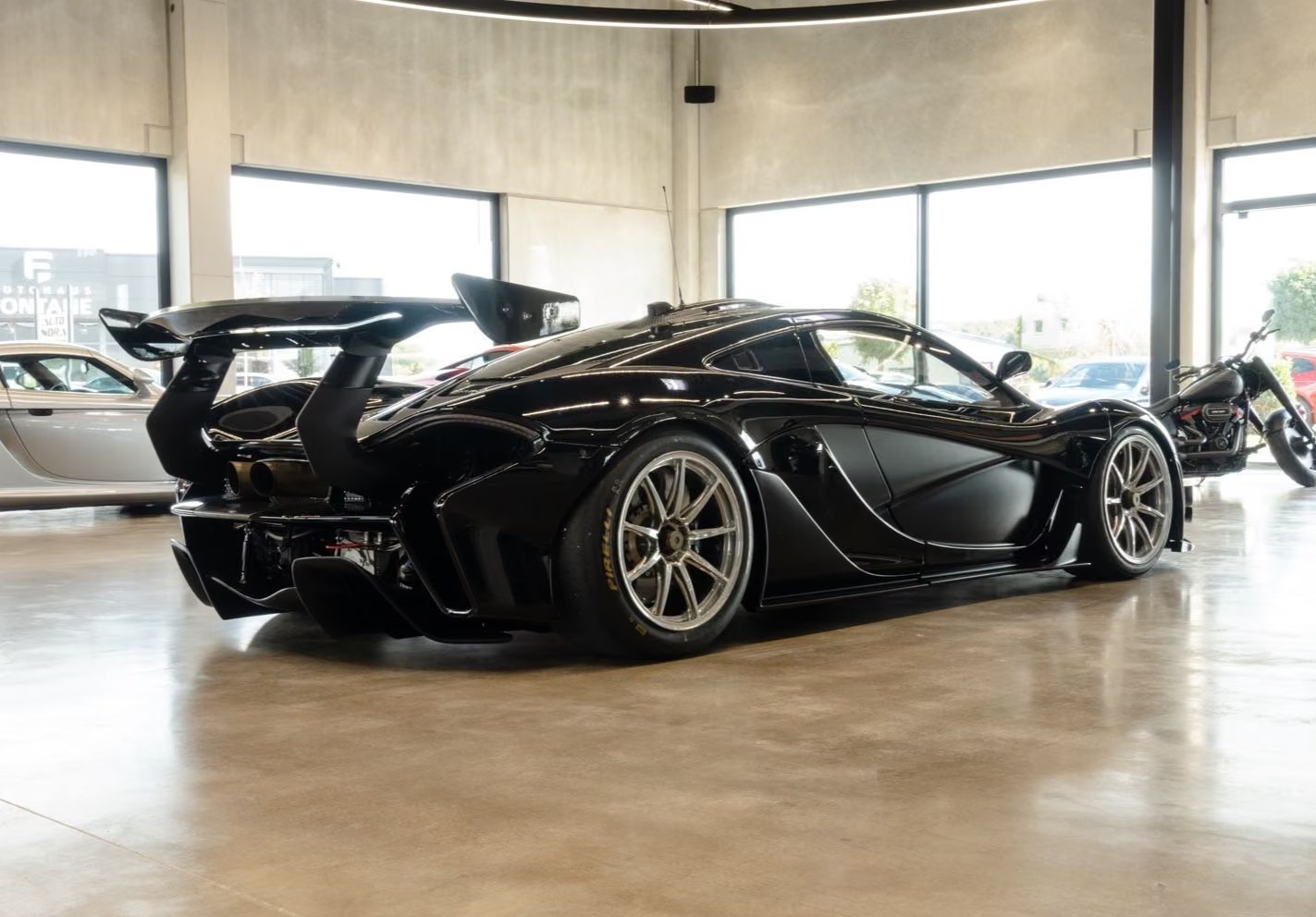 Side rear view of the McLaren P1 GTR showing the large rear wing and central exhaust.