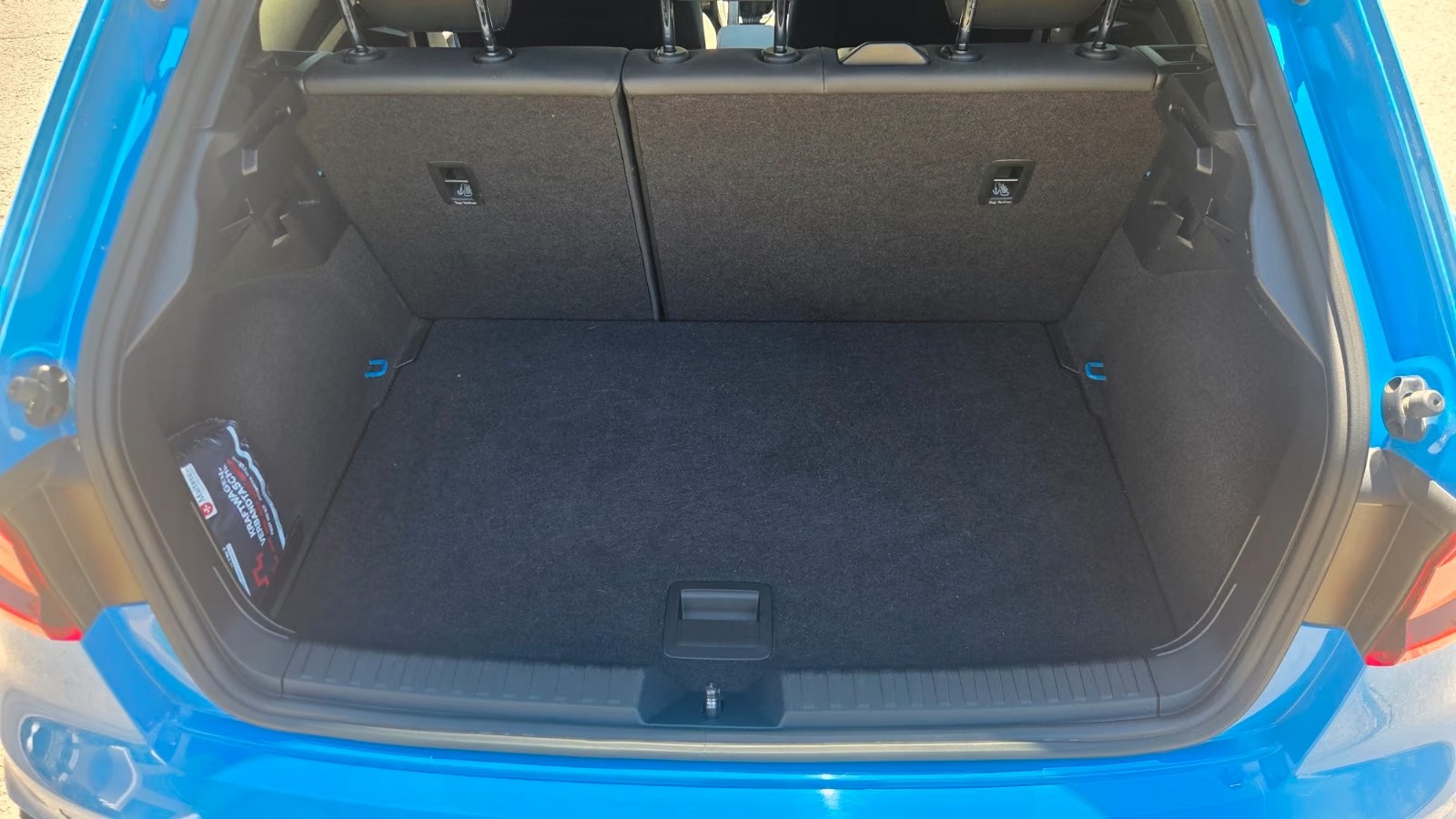 Open boot of the Audi A1 Sportback showing the carpeted luggage compartment and folding rear seat backs.
