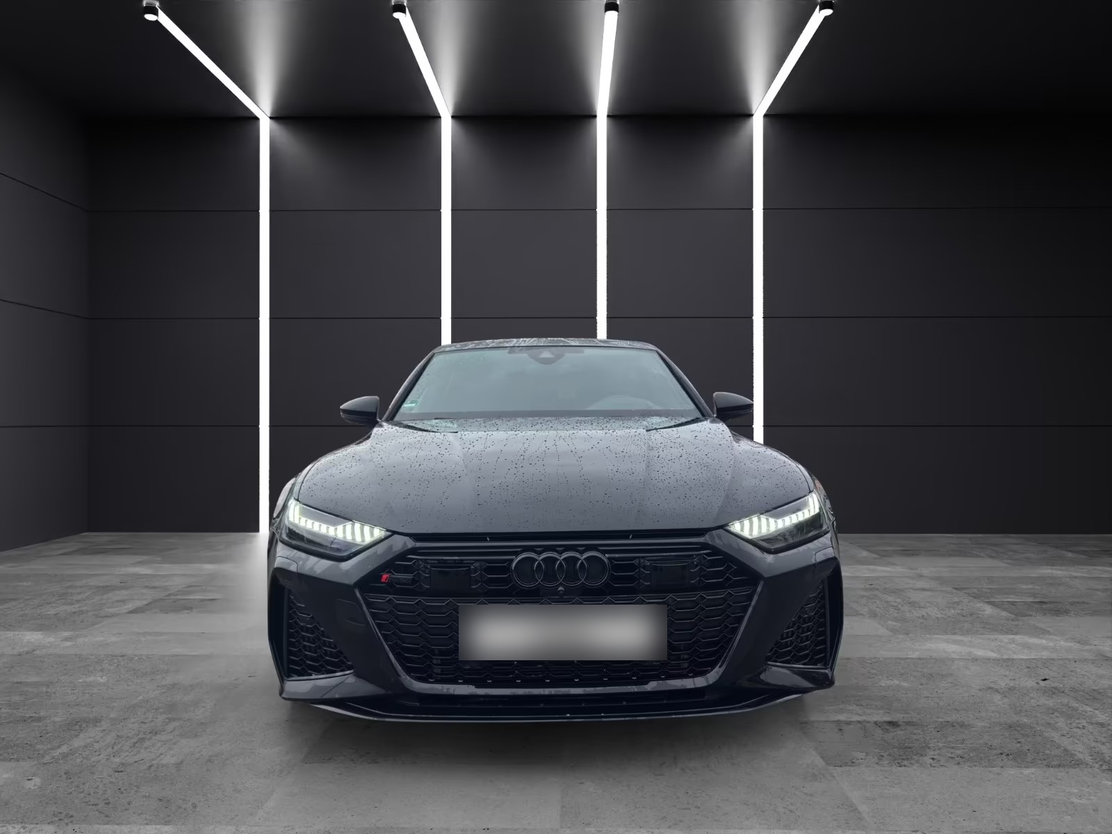 Audi RS7 Sportback in Mythosschwarz metallic, head-on front view in a dark studio with LED light strips.