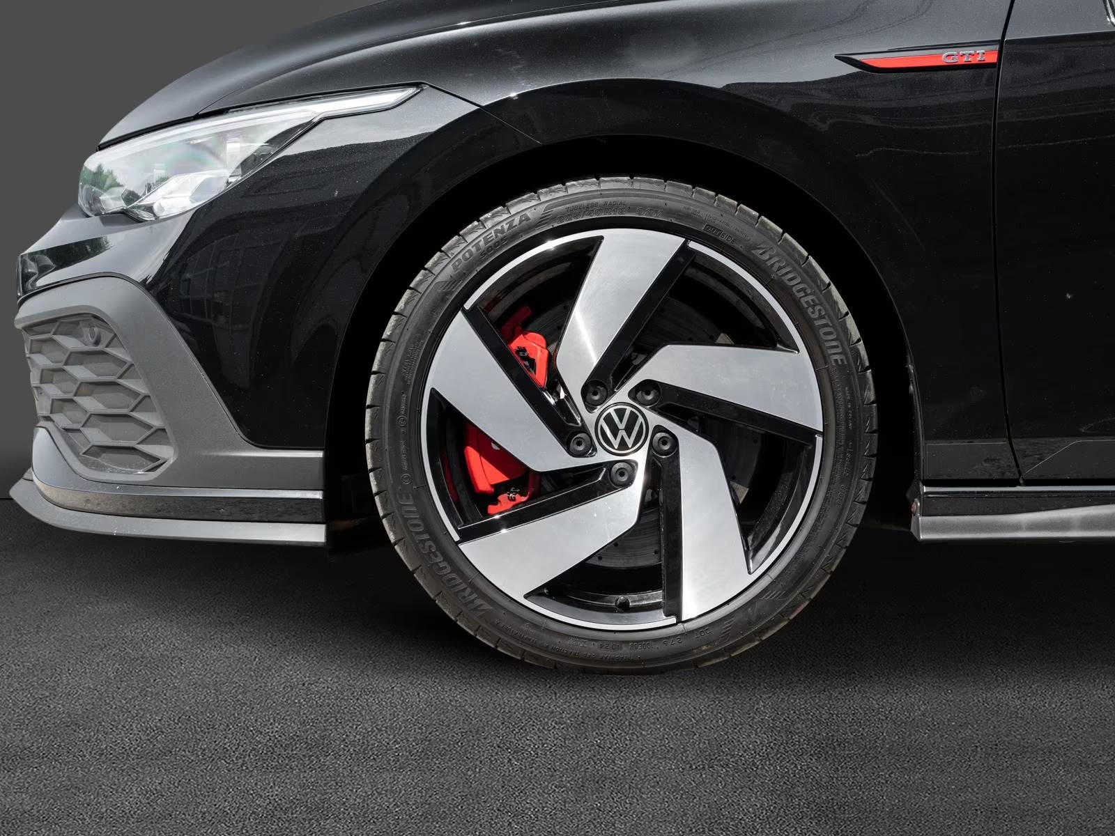 Close-up of the GTI Clubsport front wheel with red brake caliper and Bridgestone tyre.