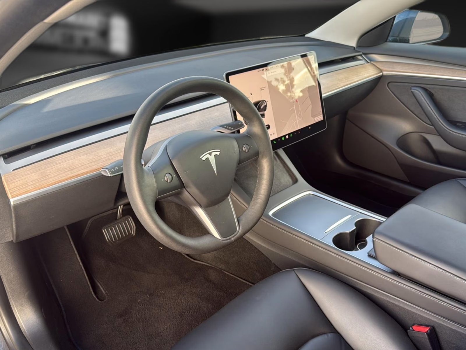 Tesla Model 3 steering wheel and touchscreen showing the navigation map.