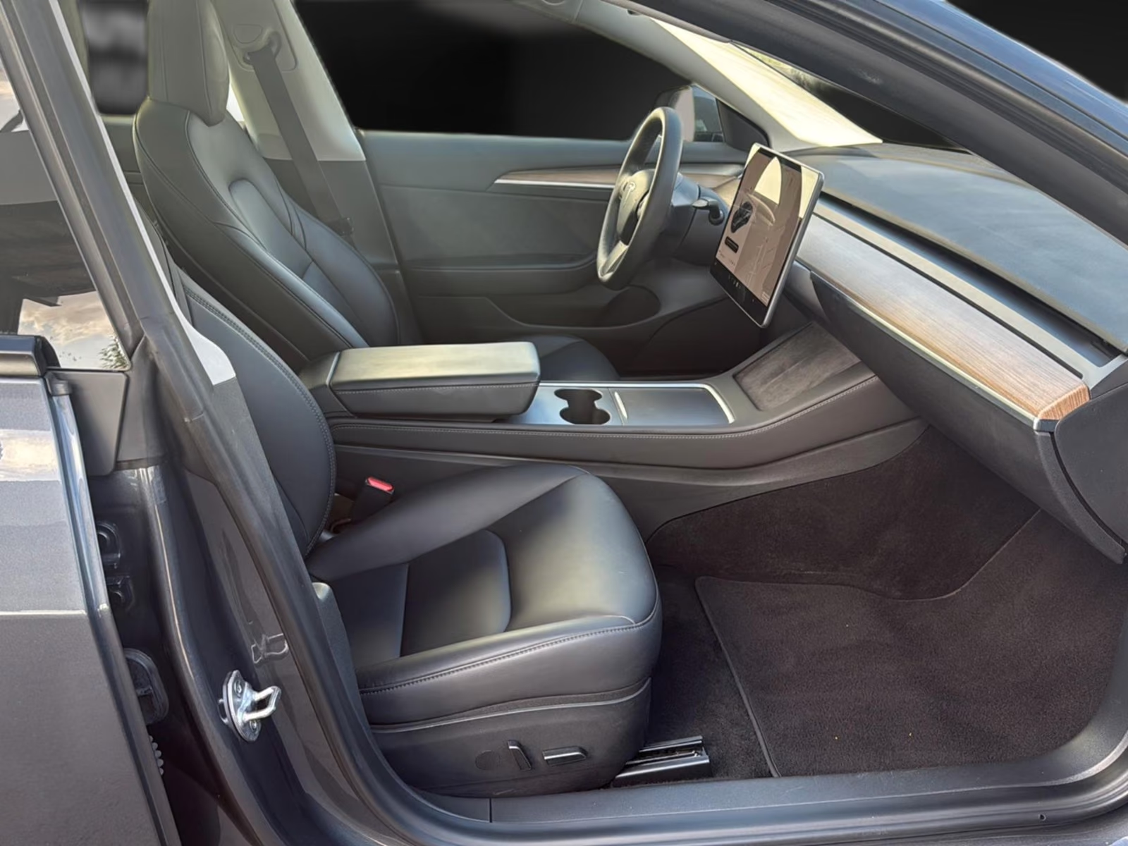 Tesla Model 3 front cabin in black leather with central touchscreen and centre console.
