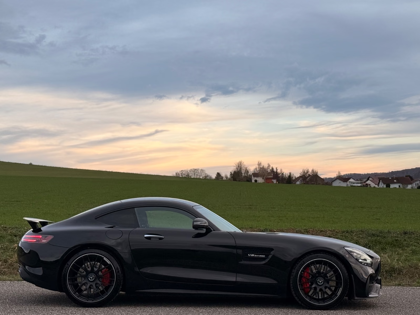 Side profile of the Mercedes-AMG GT C Coupé showing the long bonnet, low roofline and red brake calipers.