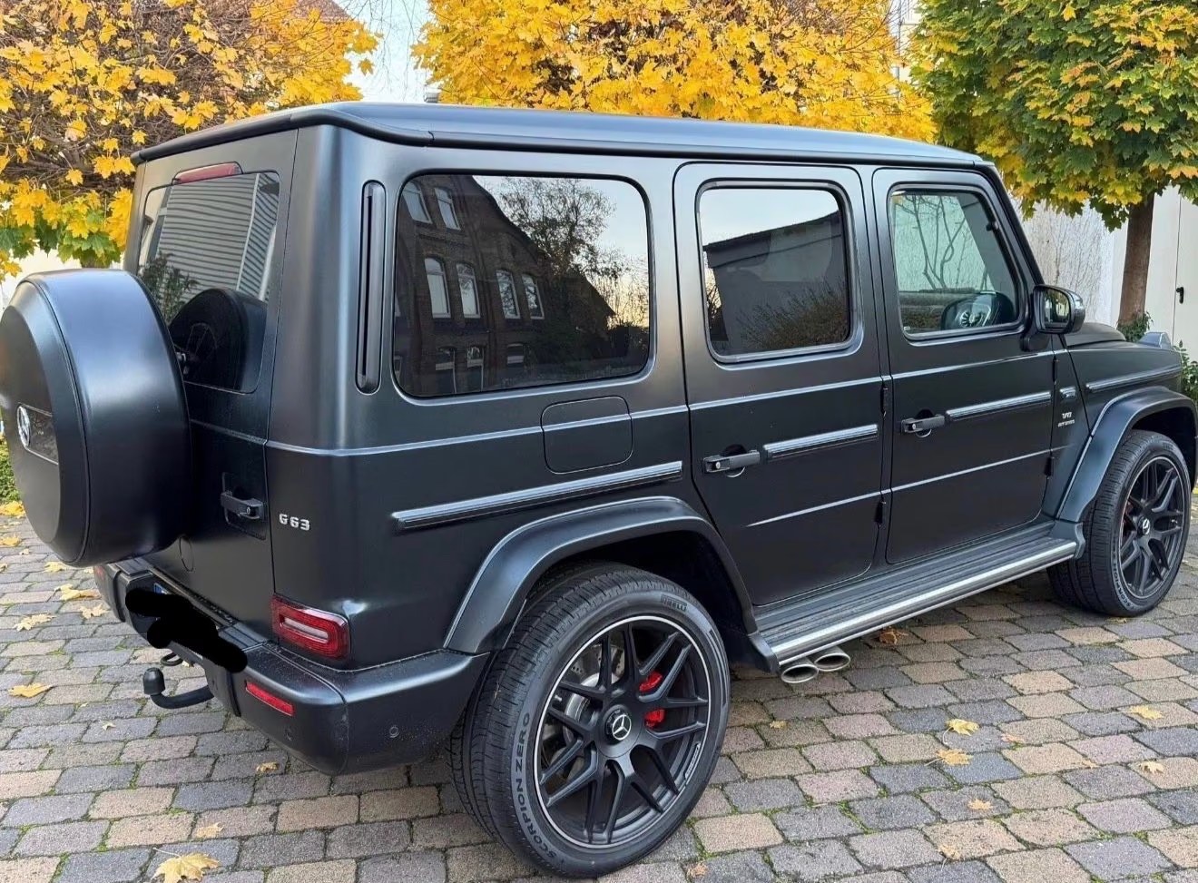 Rear three-quarter view of the AMG G 63 showing the G 63 badge and spare wheel cover.