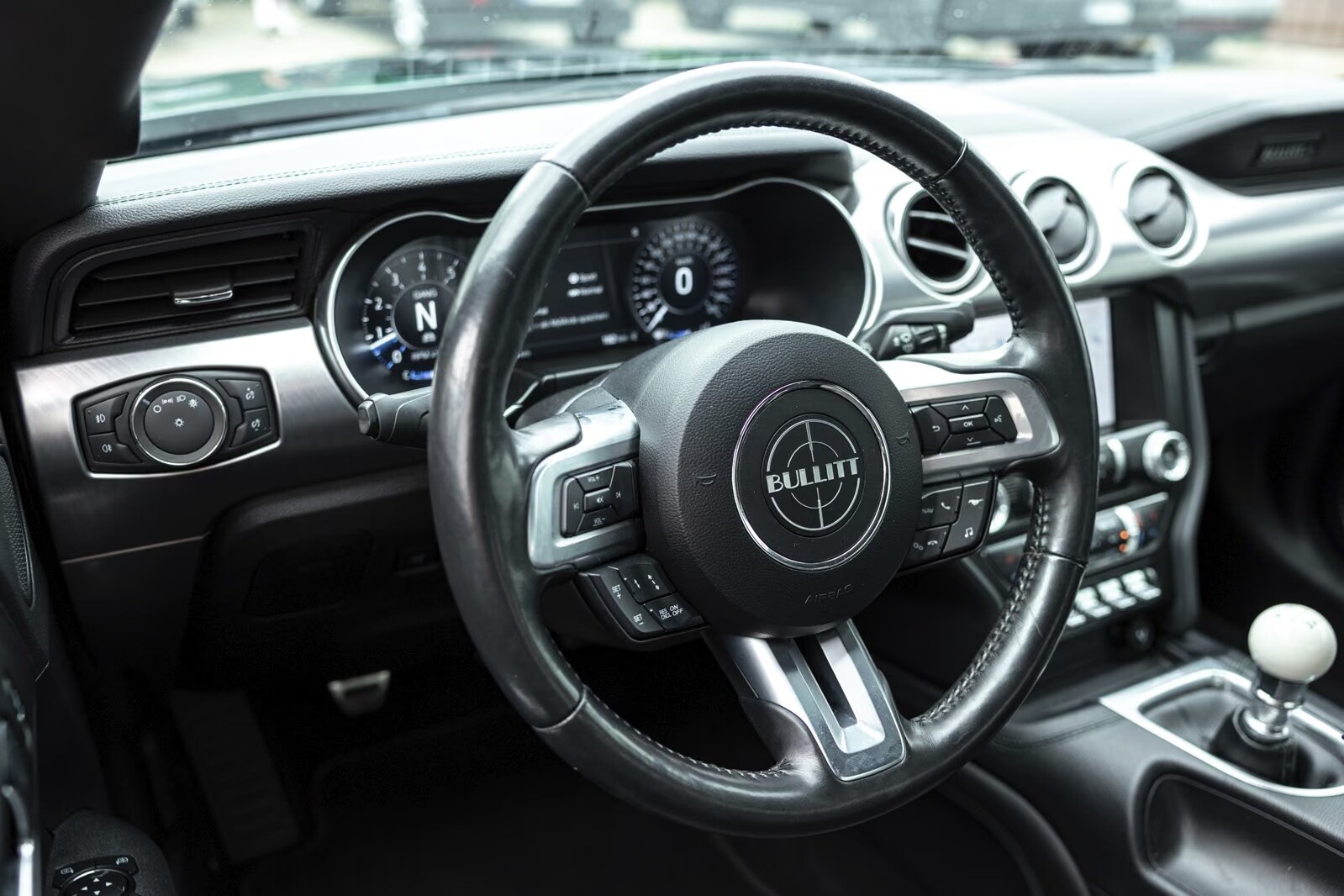 Bullitt steering wheel and digital instrument cluster with the white cue-ball shifter visible.