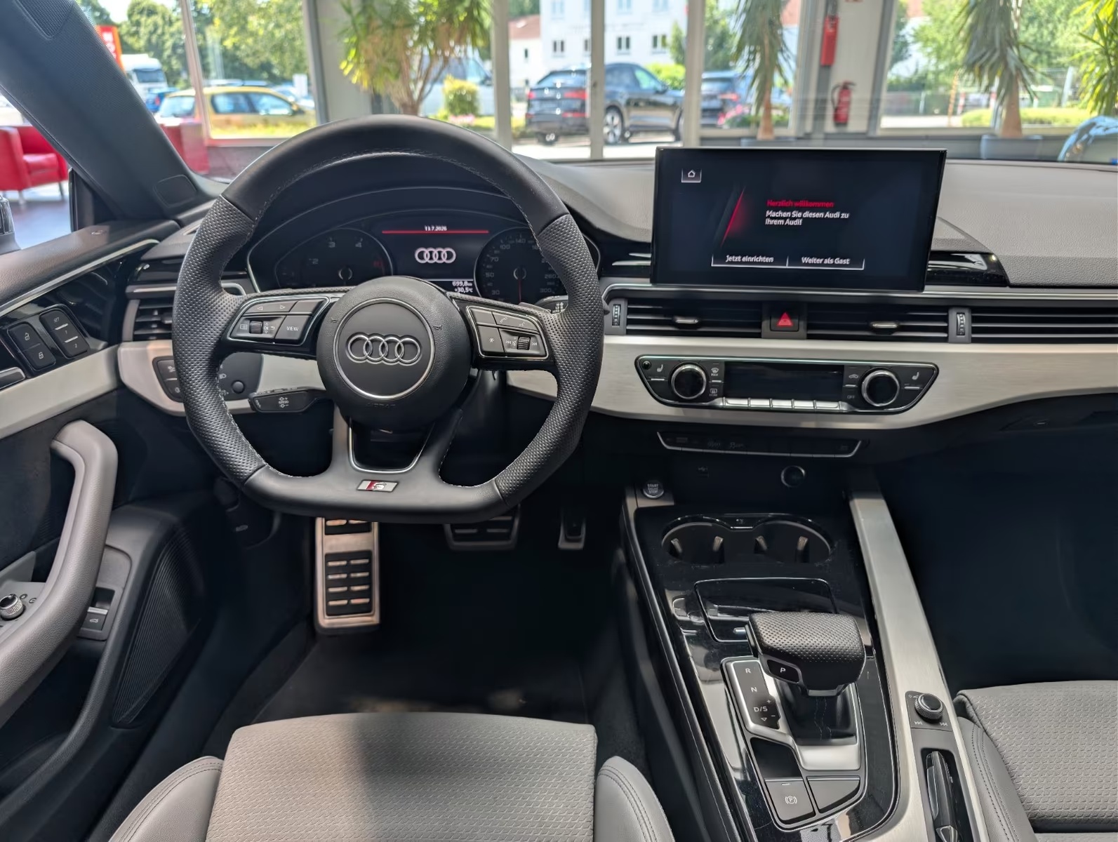 Dashboard of the Audi A5 Sportback showing the multifunction steering wheel, digital instrument display, central touchscreen and automatic gear selector.