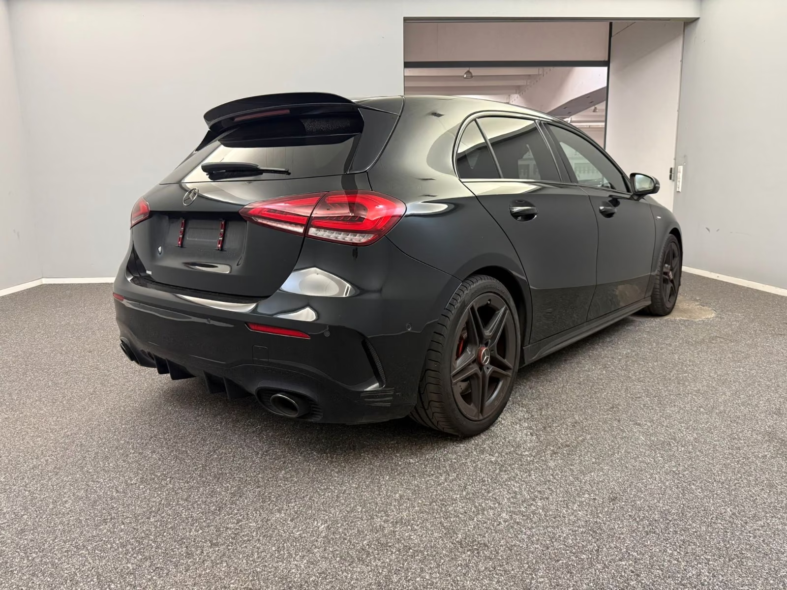 Mercedes-AMG A 35 4MATIC 2021 — rear three-quarter view with diffuser and roof spoiler