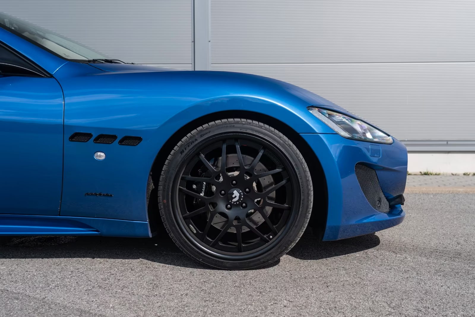 Front alloy wheel with drilled brake disc of the Maserati GranTurismo Sport.