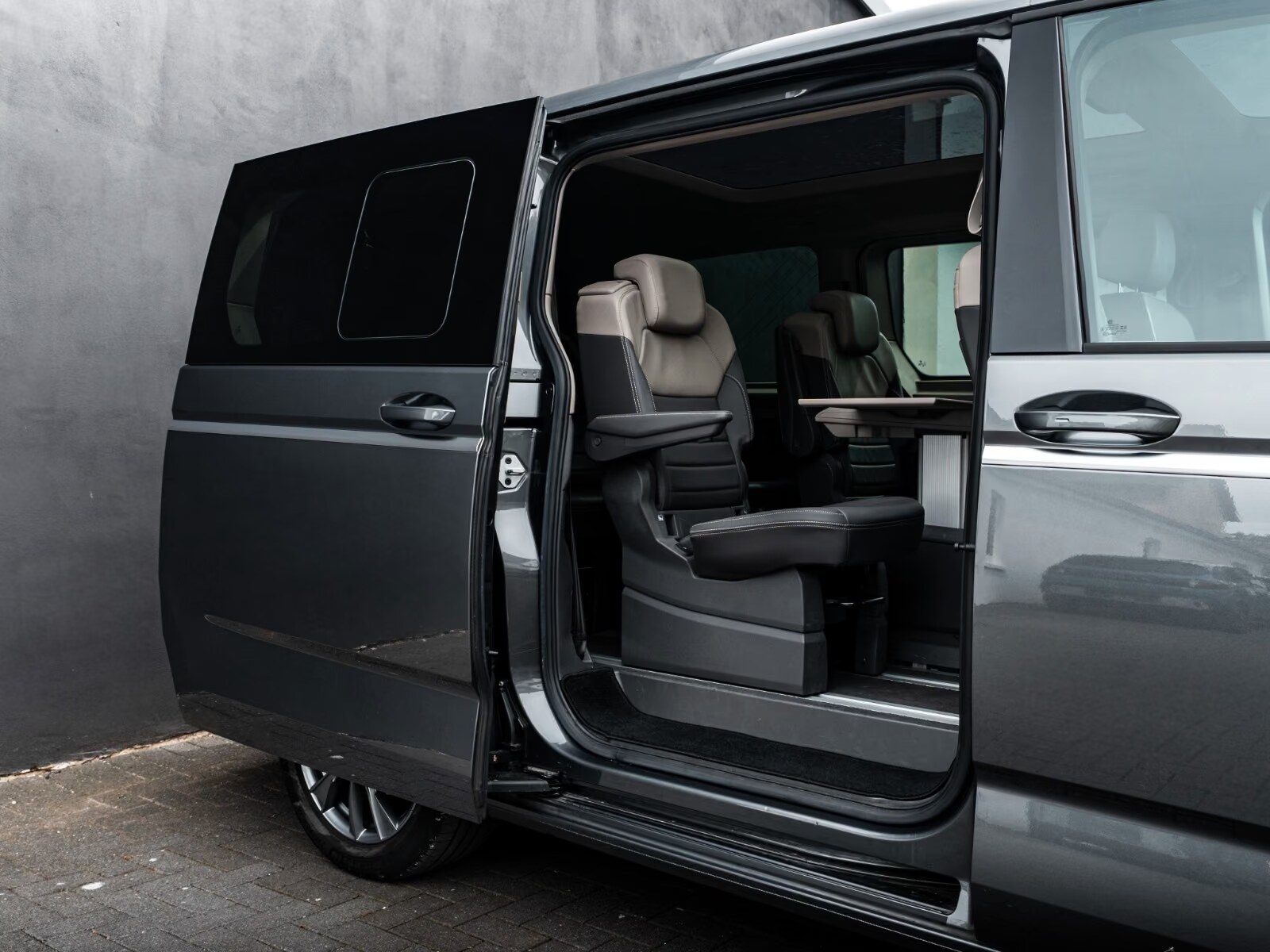 Open sliding door of the T7 Multivan showing the second-row individual seats.