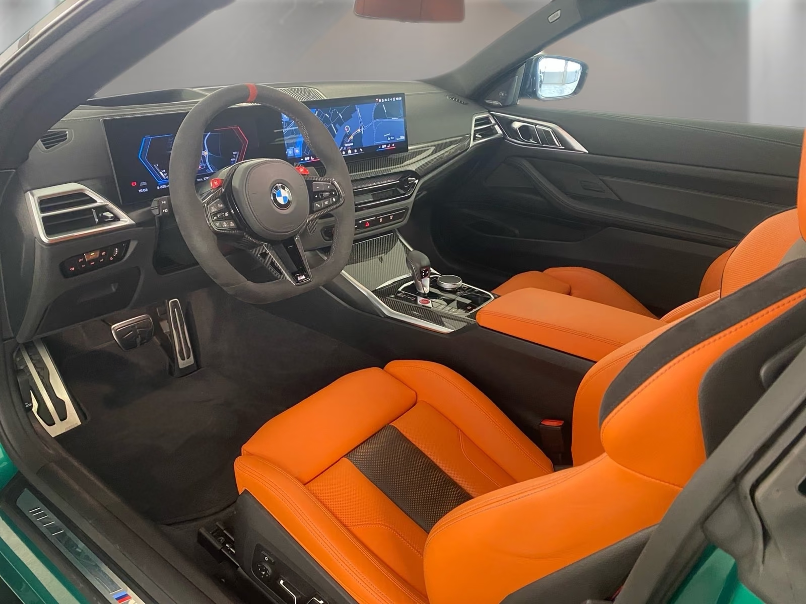 Cockpit of the BMW M4 with curved display and carbon centre console.
