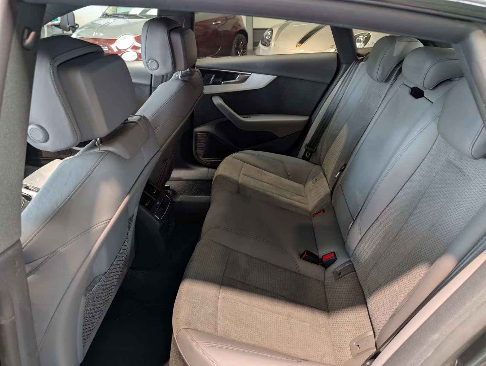 Rear interior of the Audi A5 Sportback showing the rear bench, part-leather upholstery, centre armrest and door panel.