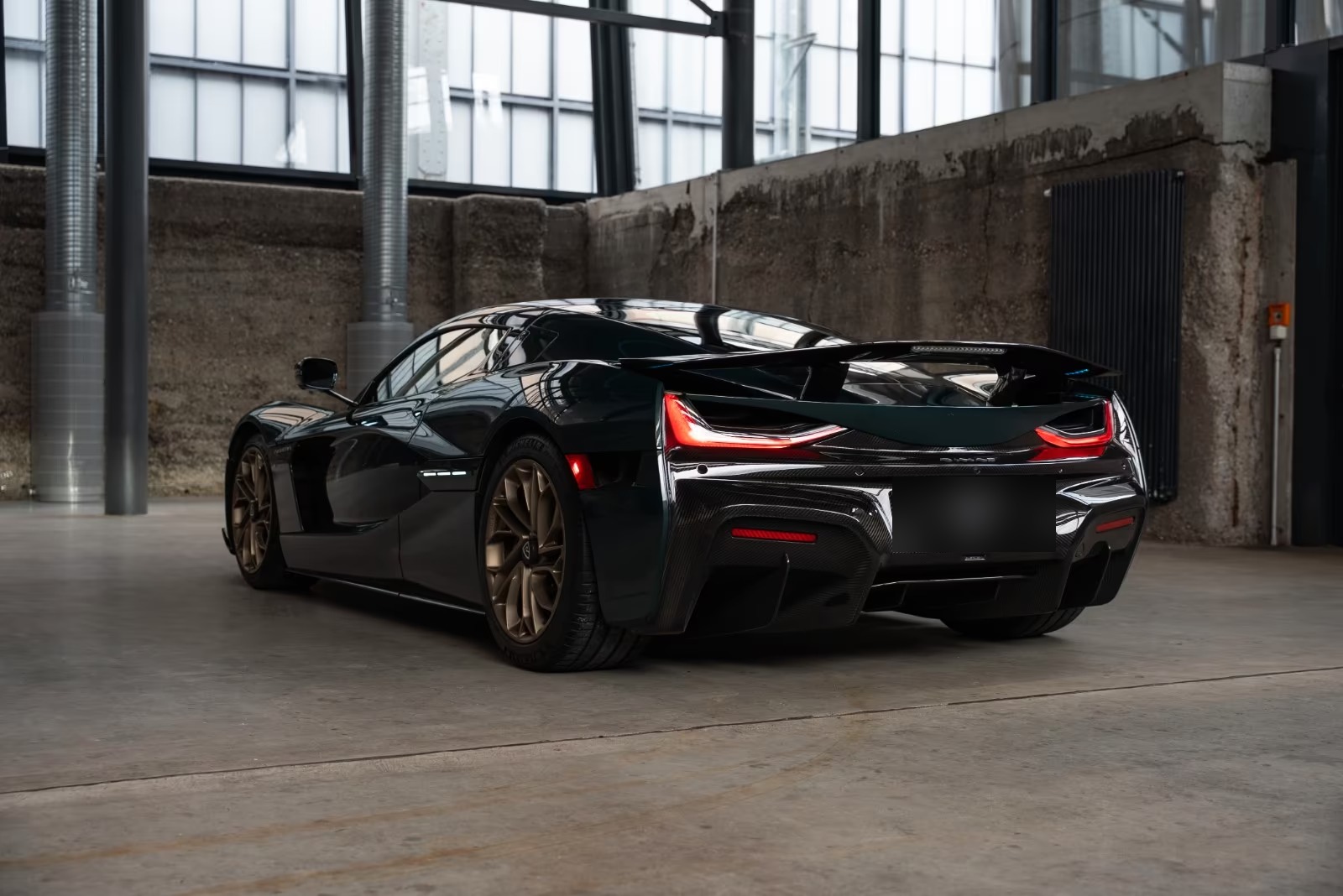 Rear three-quarter view of the Rimac Nevera showing the carbon diffuser and light bar.