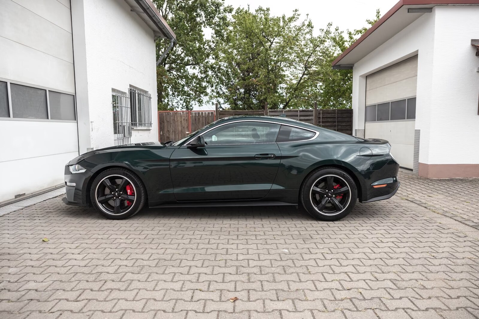 Dark Highland Green Ford Mustang Bullitt, driver-side profile view.