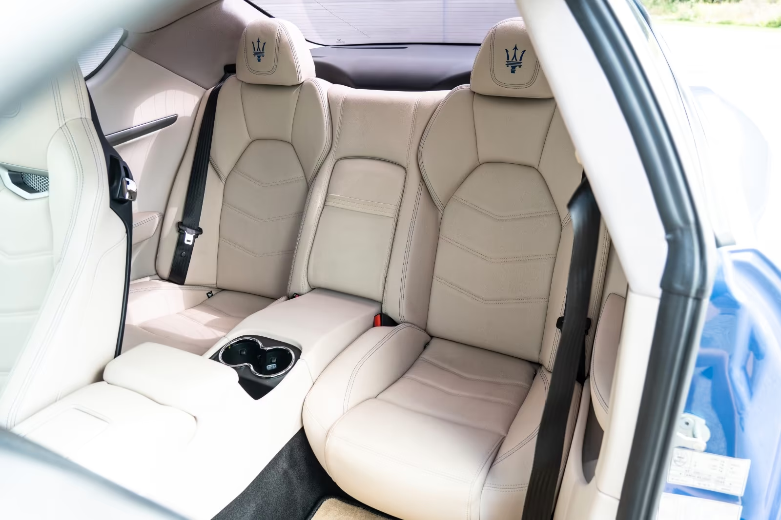Rear beige leather seats with trident headrests of the Maserati GranTurismo.