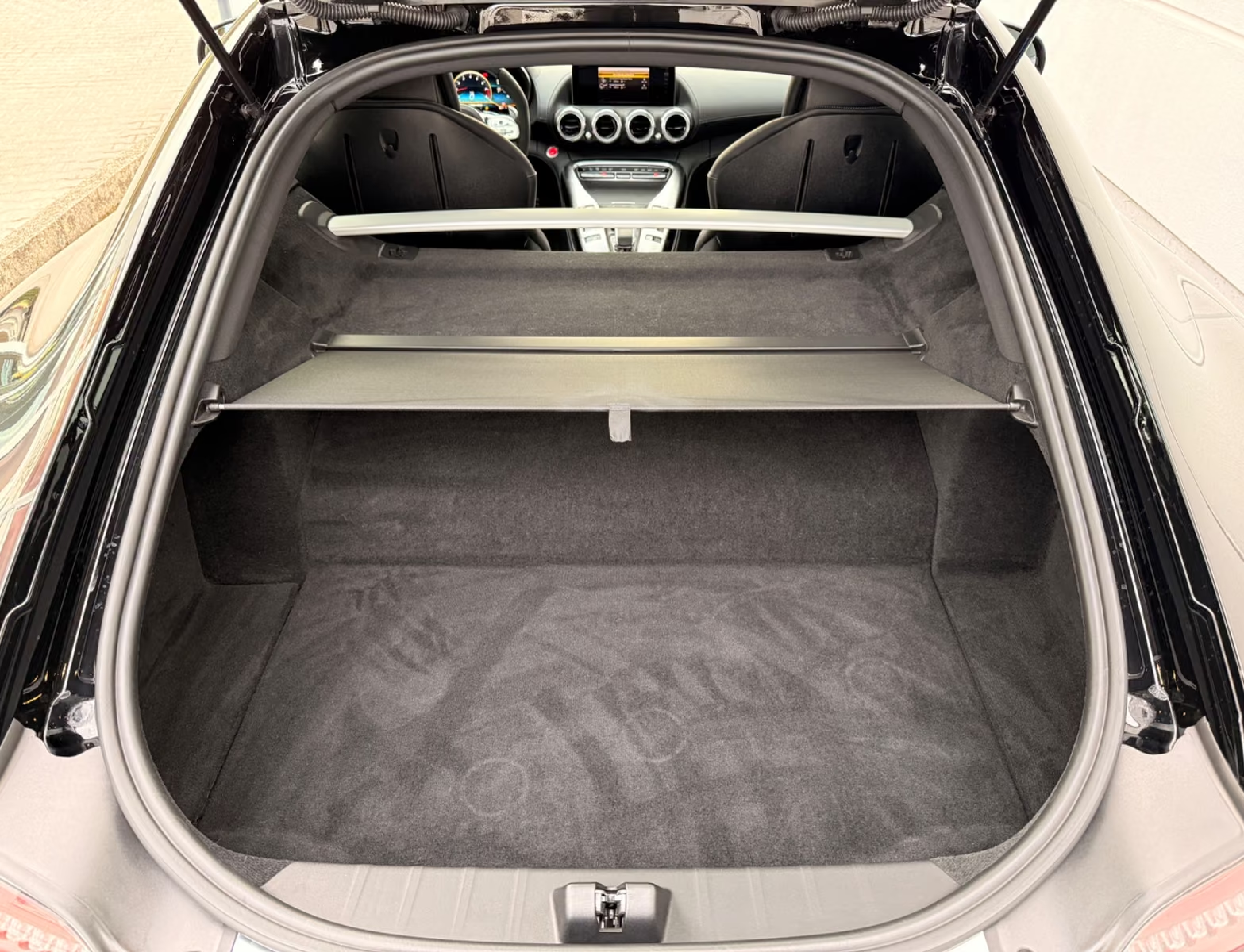 Open boot of the Mercedes-AMG GT C showing the carpeted luggage compartment and parcel shelf.