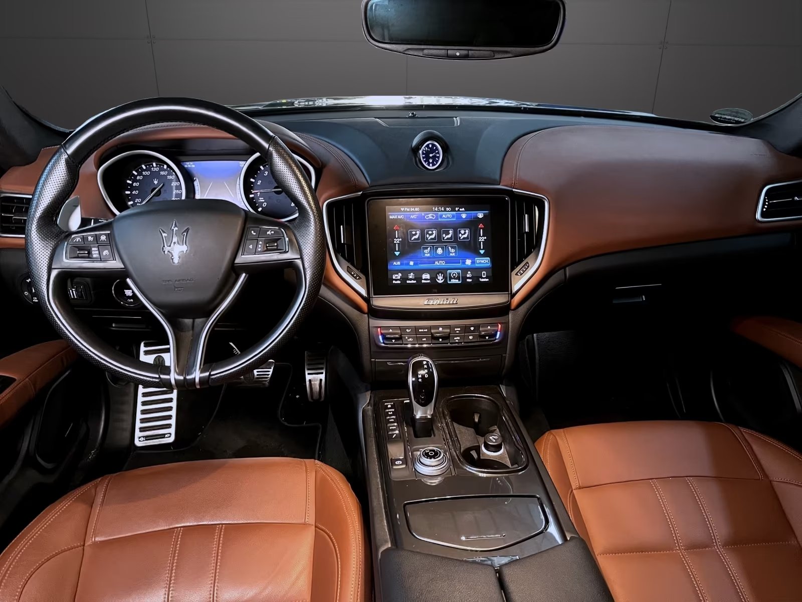 Maserati Ghibli dashboard with touchscreen infotainment and analogue clock.
