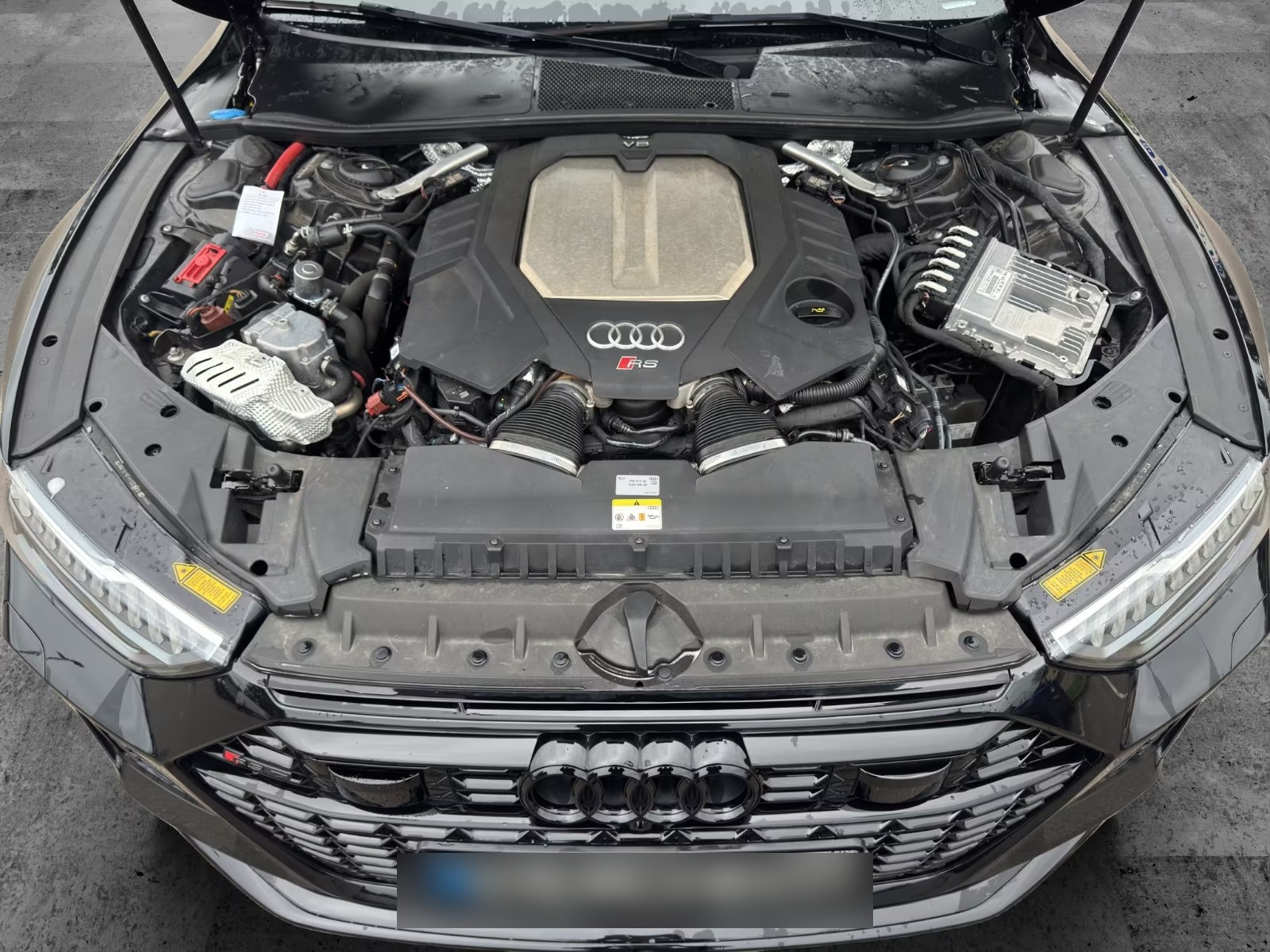 Open bonnet of the Audi RS7 showing the 4.0-litre V8 TFSI engine cover.