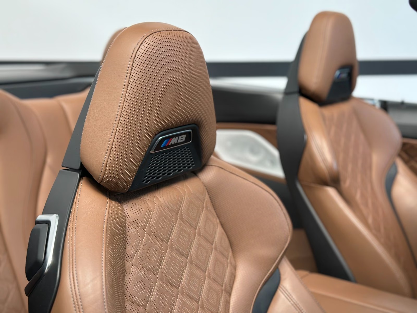 Close-up of the cognac Merino leather M sport seats with M8 badged headrests.
