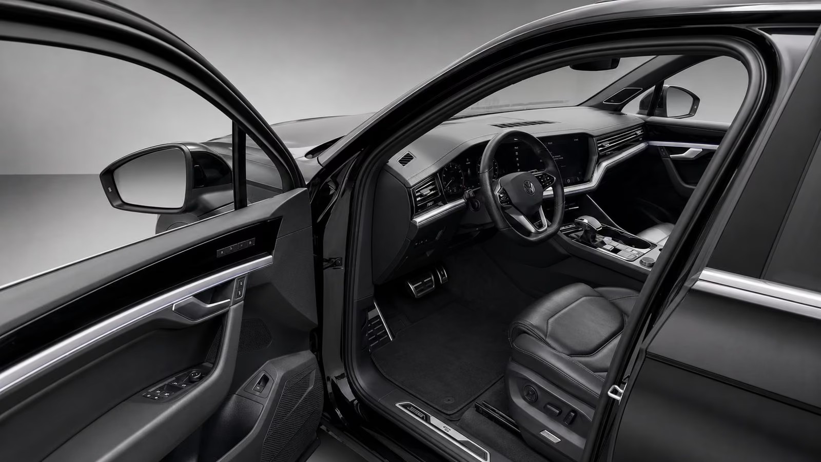 Open driver's door of the Touareg showing the grey leather seats and dashboard.