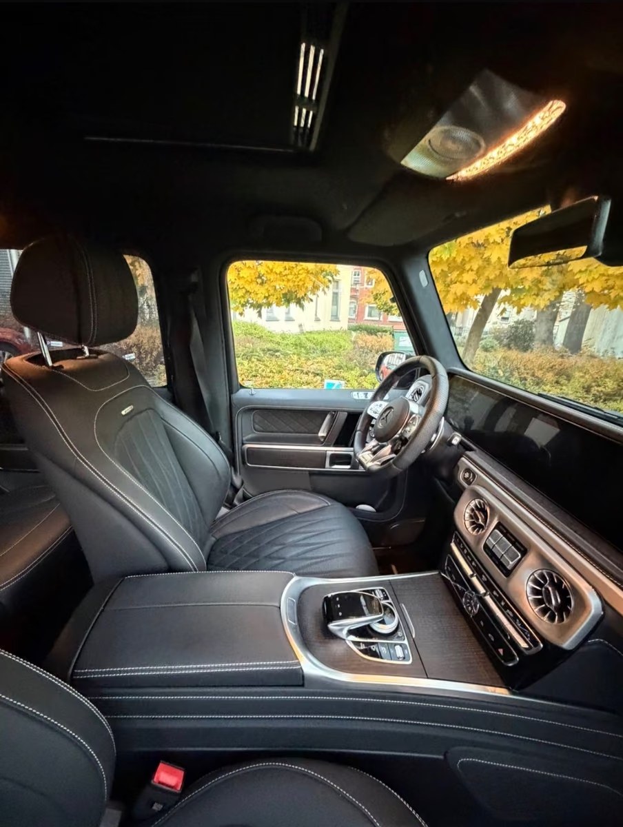 Driver's cockpit of the G 63 with black leather, wood trim and turbine vents.