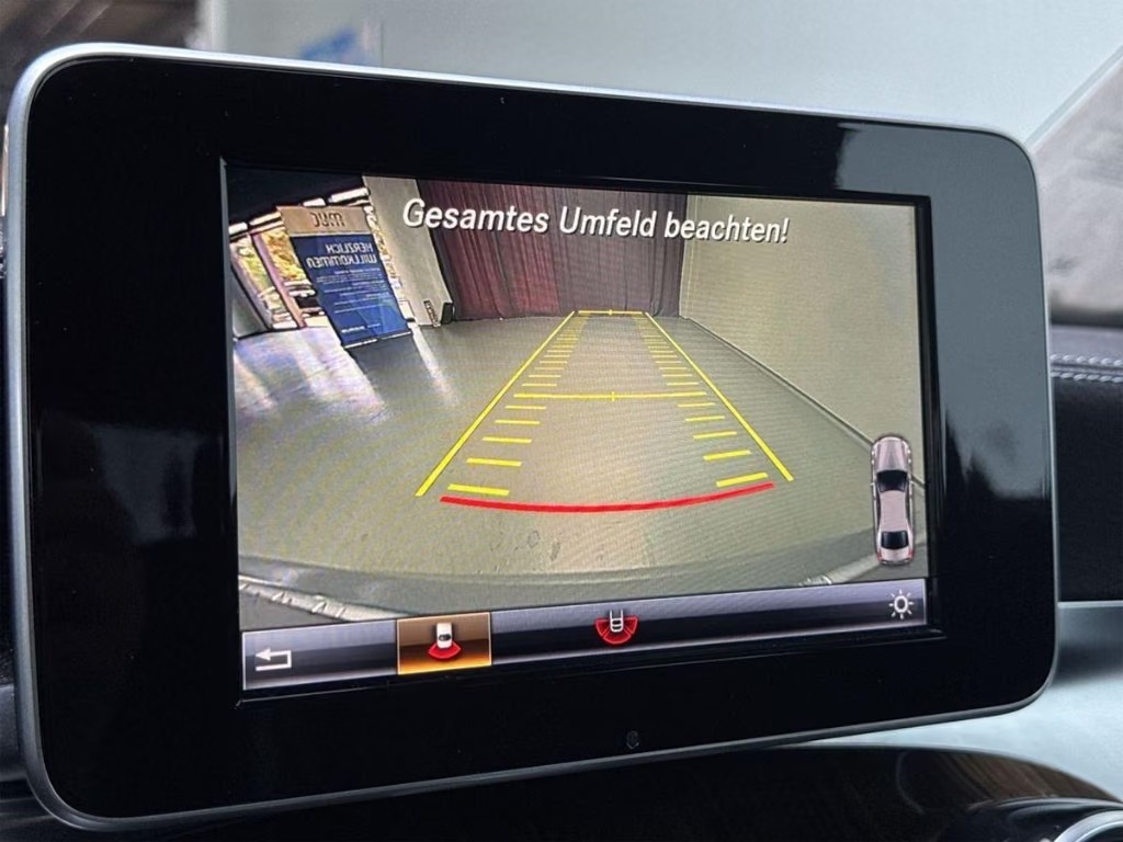 Central display of the Mercedes-Benz GLC showing the reversing camera image with parking guidance lines.