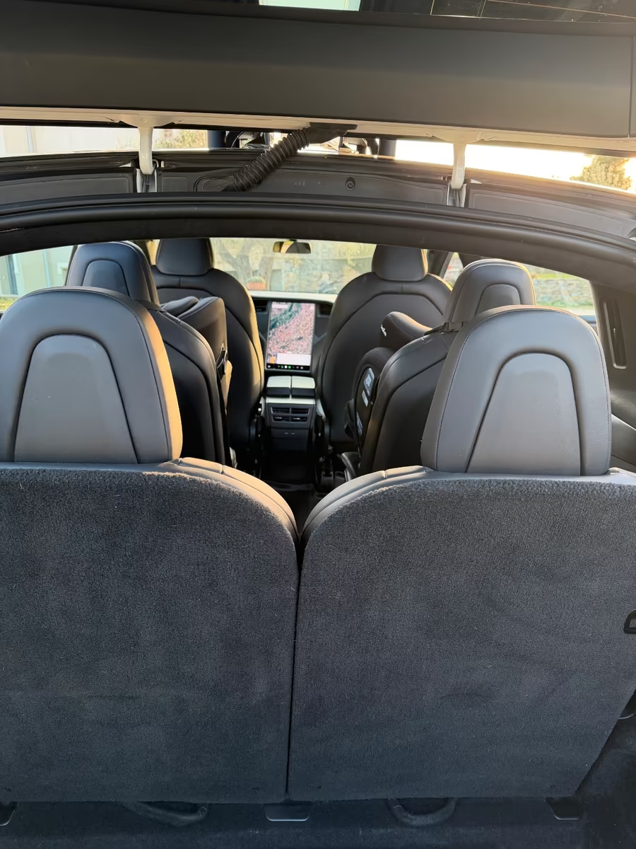 Six-seat black leather interior of the Tesla Model X seen from the boot.