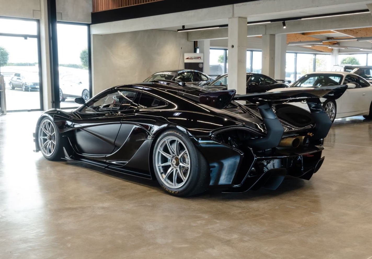 Rear three-quarter view of the black McLaren P1 GTR showing the fixed rear wing and slick tyres.