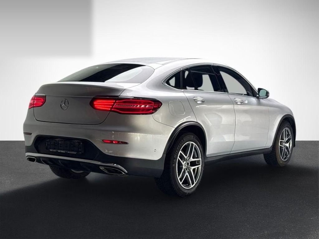 Rear three-quarter view of the Mercedes-Benz GLC 300 Coupé showing the sloping coupé roofline, rear lights and 19-inch AMG alloy wheels.