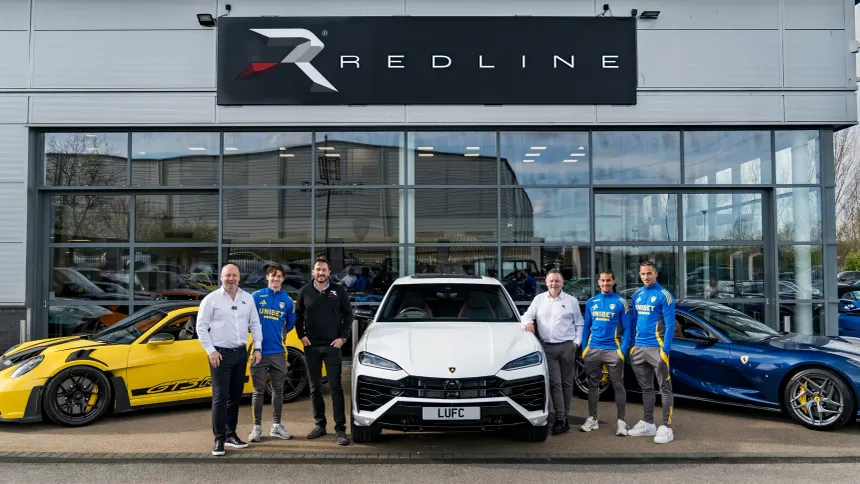 The Redline team standing with performance vehicles outside the Redline showroom