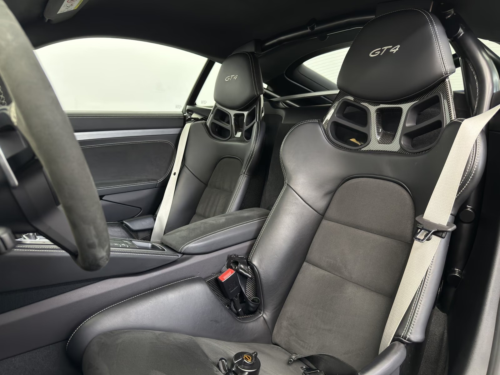 Interior of the Porsche 718 Cayman GT4 showing the two GT4-embroidered sports seats in leather and Race-Tex with contrast stitching.