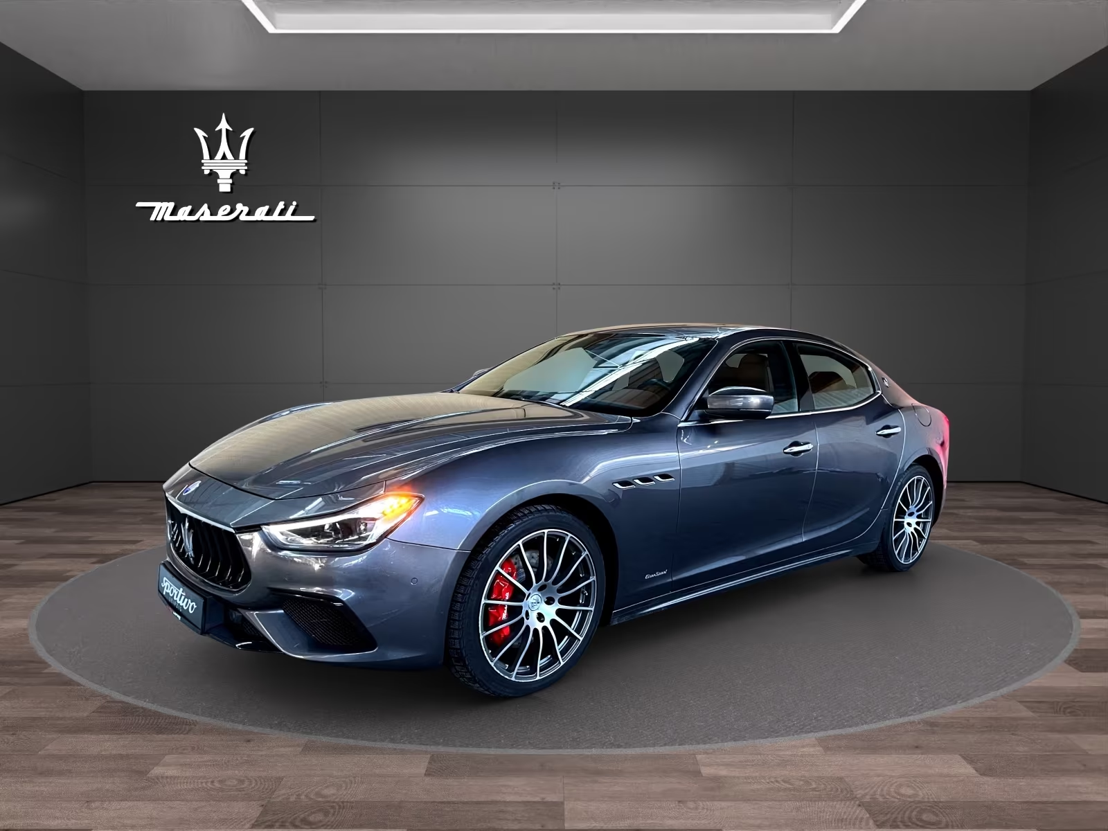 Front three-quarter view of the Grigio Maratea Maserati Ghibli S Q4 in the showroom.