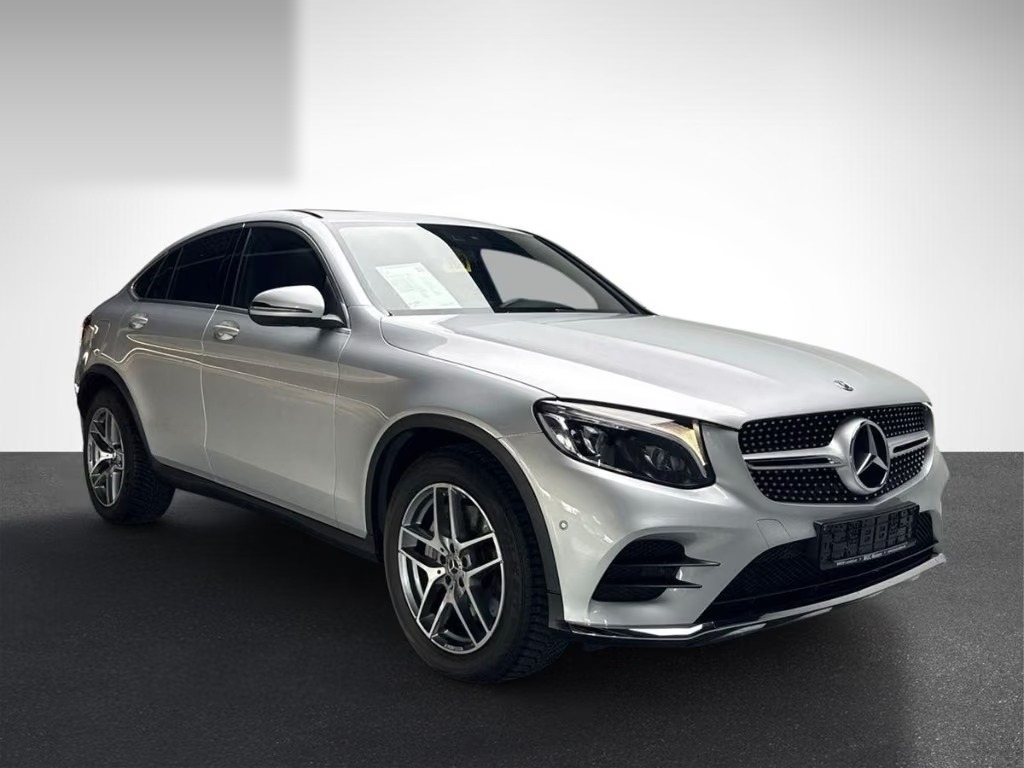 Front three-quarter view of the silver Mercedes-Benz GLC 300 Coupé from the passenger side showing the AMG Line front bumper and alloy wheels.
