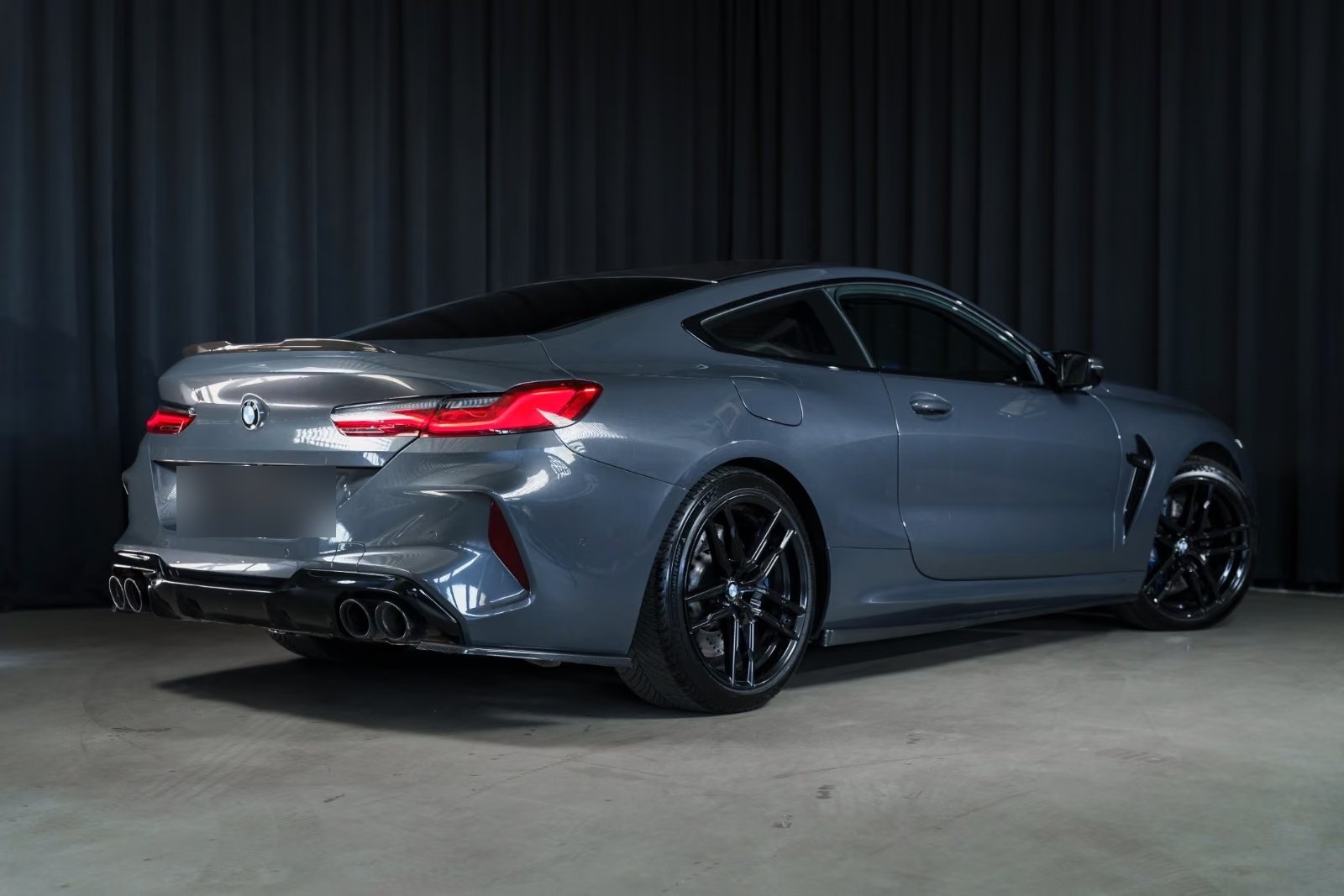 Rear three-quarter view of the BMW M8 Coupé showing the quad exhaust and carbon diffuser.