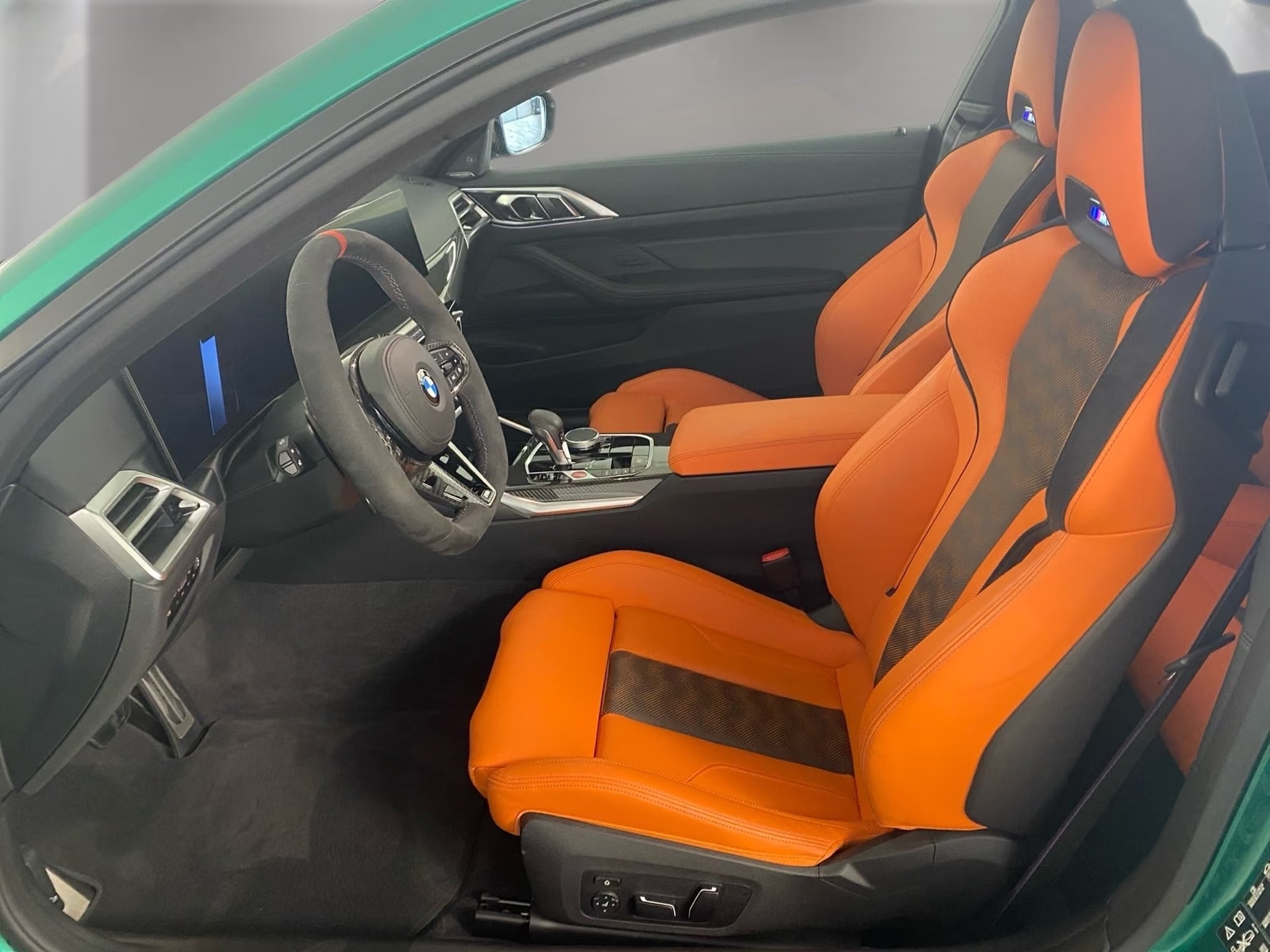 Driver's side interior with Merino Kyalami Orange and Black M sports seats.