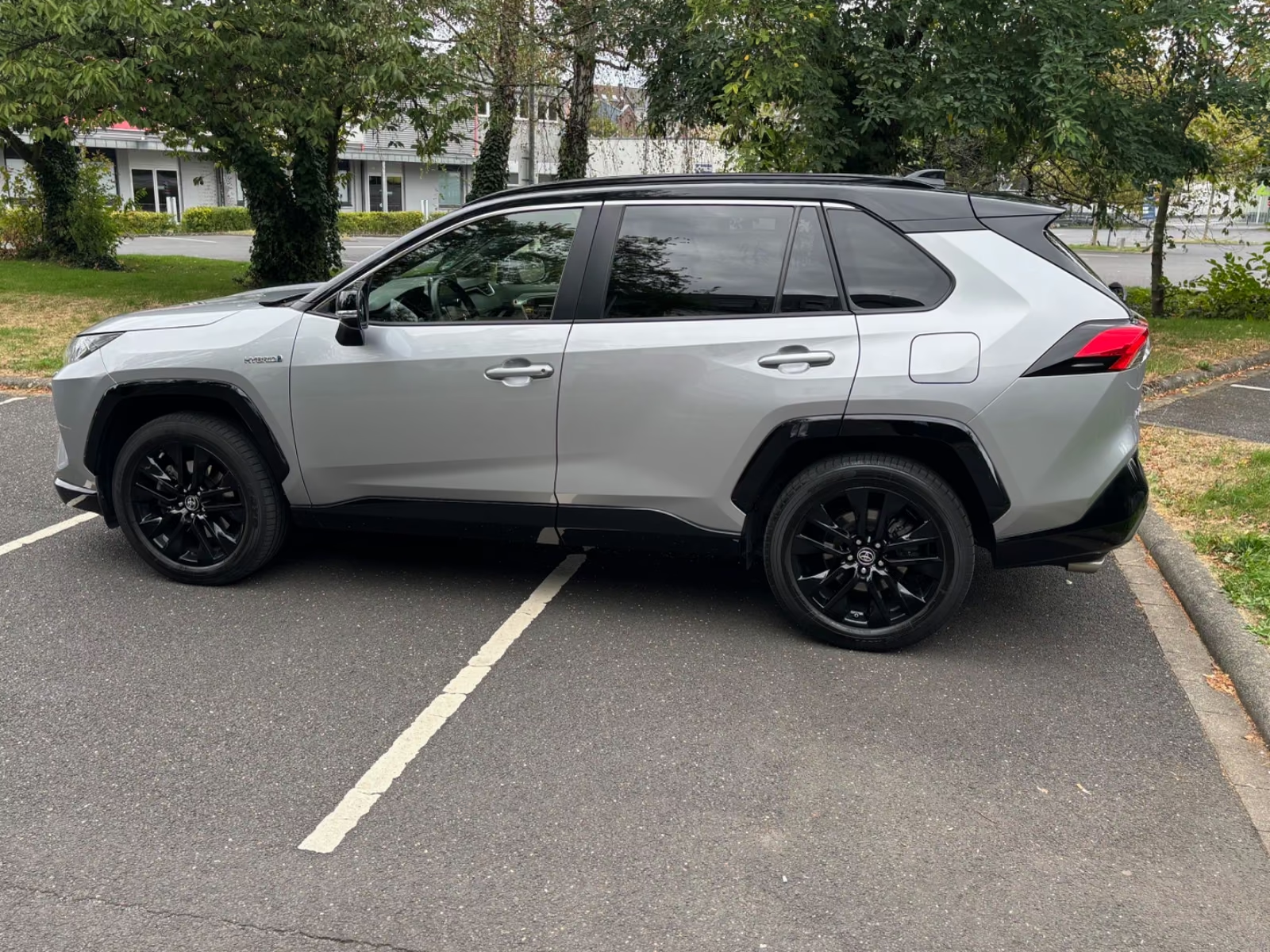 Side profile of the Toyota RAV4 Hybrid with black alloy wheels.