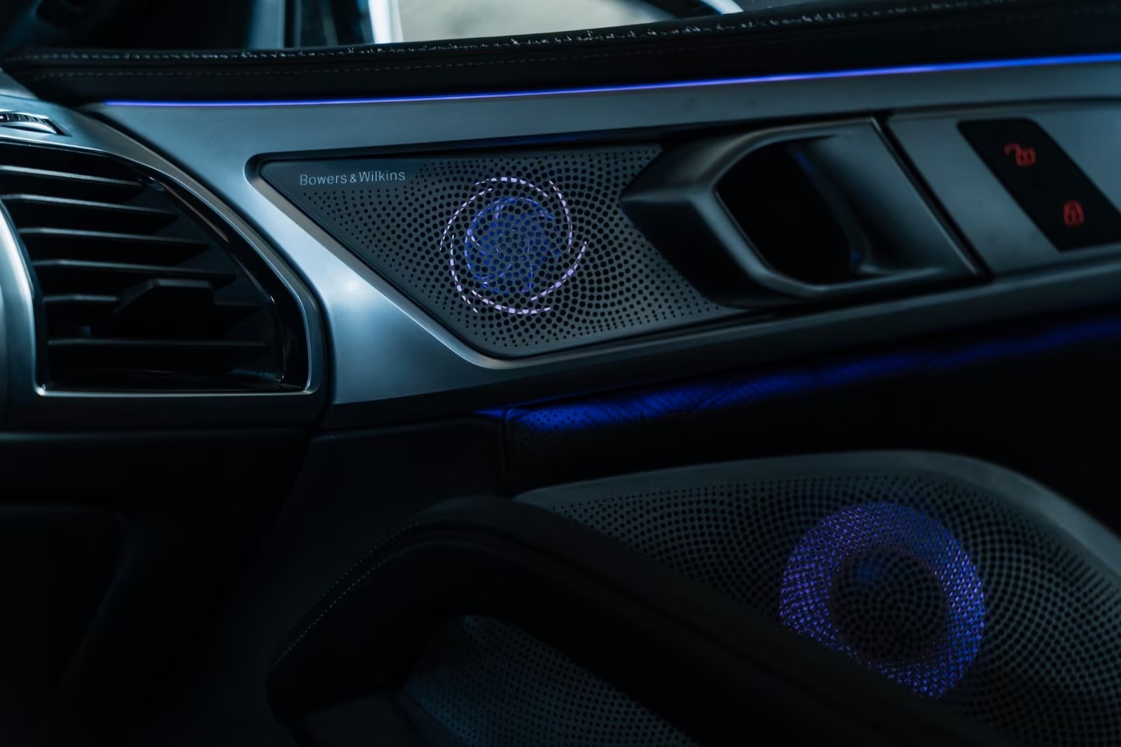 Illuminated Bowers & Wilkins speaker grille and ambient lighting in the BMW M8 door trim.